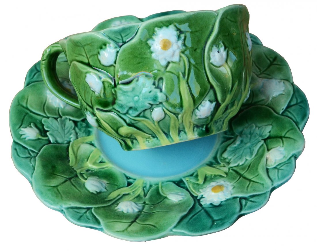 An extremely rare Minton Majolica lily cup and saucer: An extremely rare Minton Majolica lily cup and saucer c.1875, 3.5”h, marks, the cup modeled with overlapping green leaves, lily pads, and blossoms with green stem handle and turquoise interior. The 
