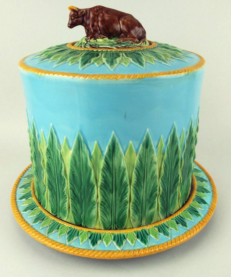 An excellent quality George Jones Majolica cow full: An excellent quality George Jones Majolica cow full Stilton cheese keeper c.1875, modeled as a straight sided lid with stylized green acanthus around the body top and base with a recumbent cow on gras