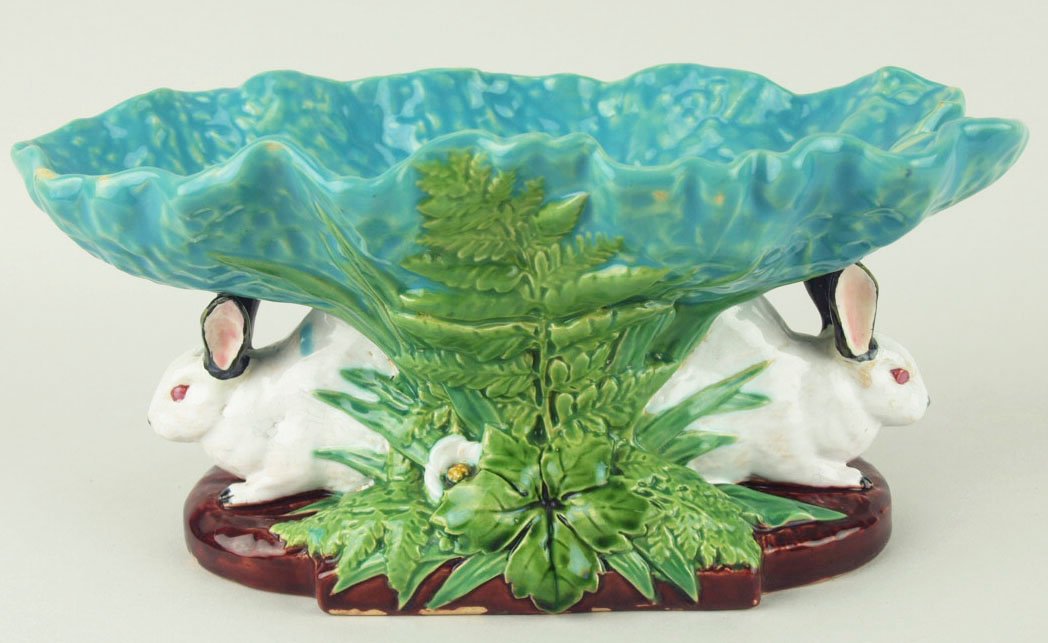 A charming Minton Majolica rabbits bon bon dish: A charming Minton Majolica rabbits bon bon dish c.1875, modeled as two back to back white rabbits peering out of a thicket of fern leaves, long grasses, and blossoms all set under a pale green lettuce