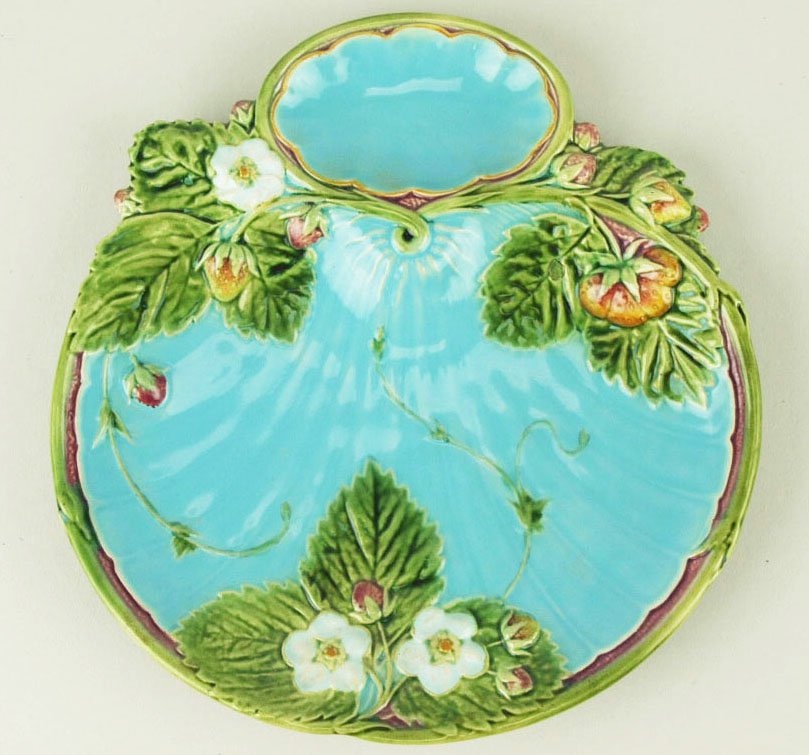 A Minton Majolica Strawberry plate c.1875, modeled as: A Minton Majolica Strawberry plate c.1875, modeled as a turquoise scallop shell decorated with strawberry plants and a separate compartment for cream, all edged with a green vine edge, 8” 'CURATED &