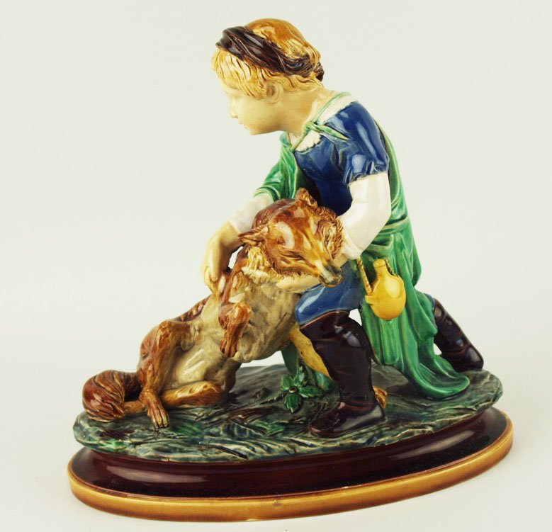 A very Rare Minton Majolica figure of a girl with a: A very Rare Minton Majolica figure of a girl with a fox c.1860, modeled by Pierre Jeannest. Designed as a girl in Medieval costume supporting a fox on a grey ground and supported by an oval cushioned 
