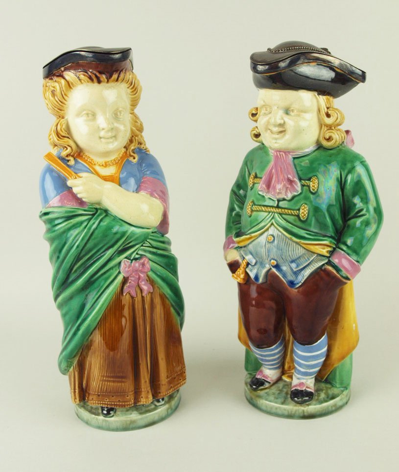 A very rare coloured pair of Minton Majolica Quaker: A very rare coloured pair of Minton Majolica Quaker man and Quaker woman silver mounted Toby pitchers c.1865, shapes no’s 1139 and 1140, 11”h. One modeled as a smiling man with hands thrust deeply