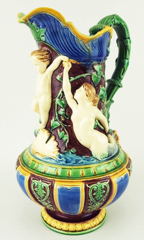 A fine Minton Majolica Rennaissance Revival ewer: A fine Minton Majolica Rennaissance Revival ewer c.1875, 12”h, impressed “Minton”, shape no 474. Decorated in relief with a cherub flanked by a merman and mermaid, with a face-mask to base of th