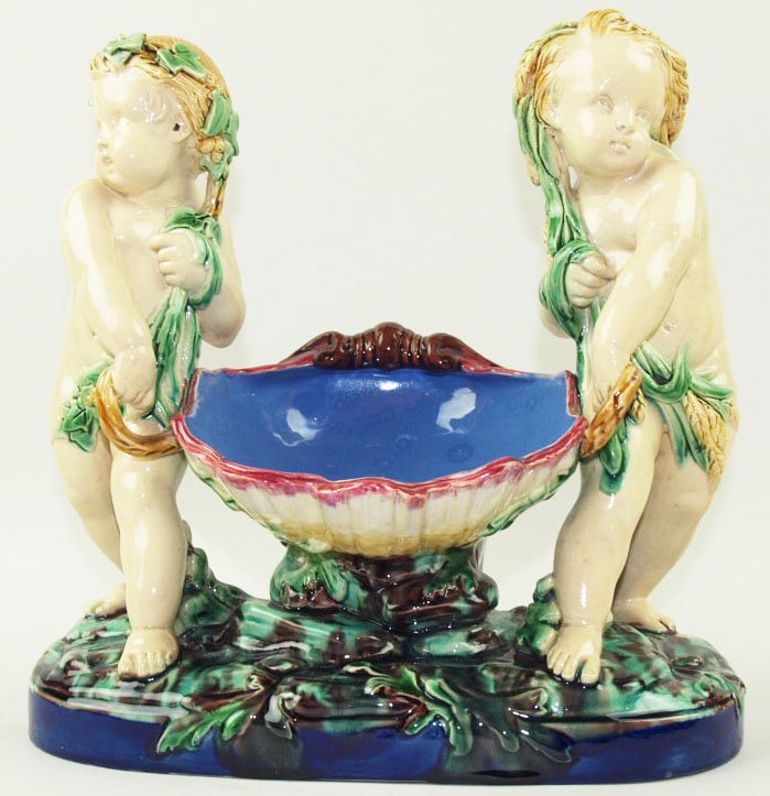 Excellent quality Minton Majolica shell carriers: Excellent quality Minton Majolica shell carriers designed by Carrier Belleuse c.1865, designed as two cherubs holding a large open conch shell with a French blue interior, supported on an oval pedesta