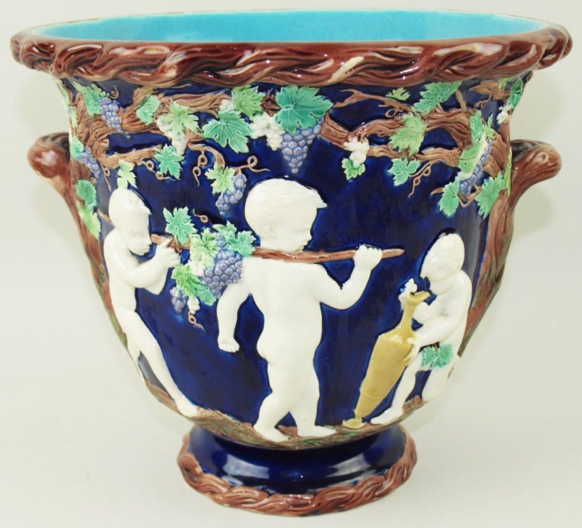 A rare and handsome Copeland Majolica Renaissance wine: A rare and handsome Copeland Majolica Renaissance wine cooler c.1865, designed as a campana shaped cobalt ground vase decorated with vines and cherubs gathering grapes, with a cherub peering into a la