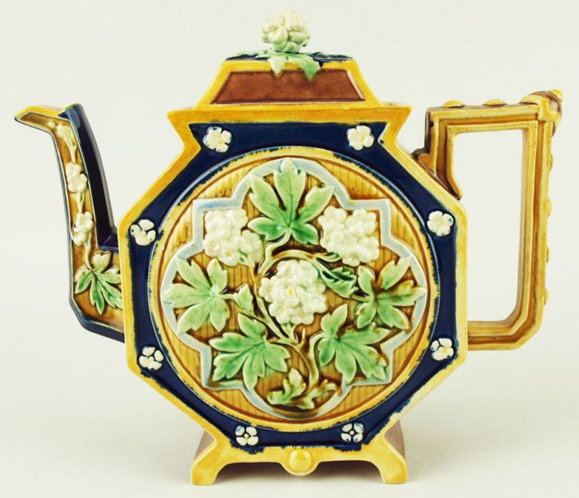 A T.C. Brown Westhead and Moore Hexagonal teapot: A T.C. Brown Westhead and Moore Hexagonal teapot c.1875, designed as a hexagonal, flat sided, brown glazed body with a circular panel of Gothic style leaves and blossoms against a blue ground to each 