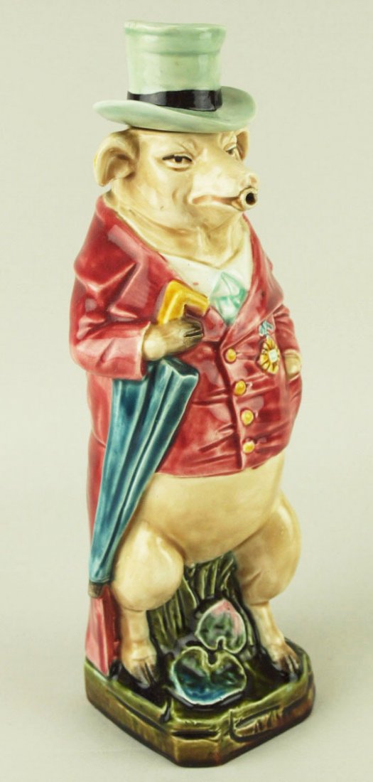 A German Majolica Pig with umbrella decanter c.1890.: A German Majolica Pig with umbrella decanter c.1890. Modeled as a pig wearing a smart red jacket with yellow buttons, a shirt and tie, a turquoise bowler hat and a blue umbrella under his arm. 'CURA