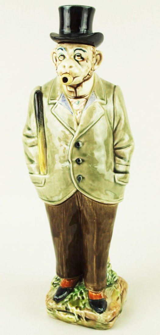 A B&L Gesetzl Gesch Majolica Suspicious Monkey: A B&L Gesetzl Gesch Majolica Suspicious Monkey decanter c.1890 Modeled as a cigar smoking monkey wearing a pale green jacket and brown trousers, spats, top hat and a truncheon protruding from his pock