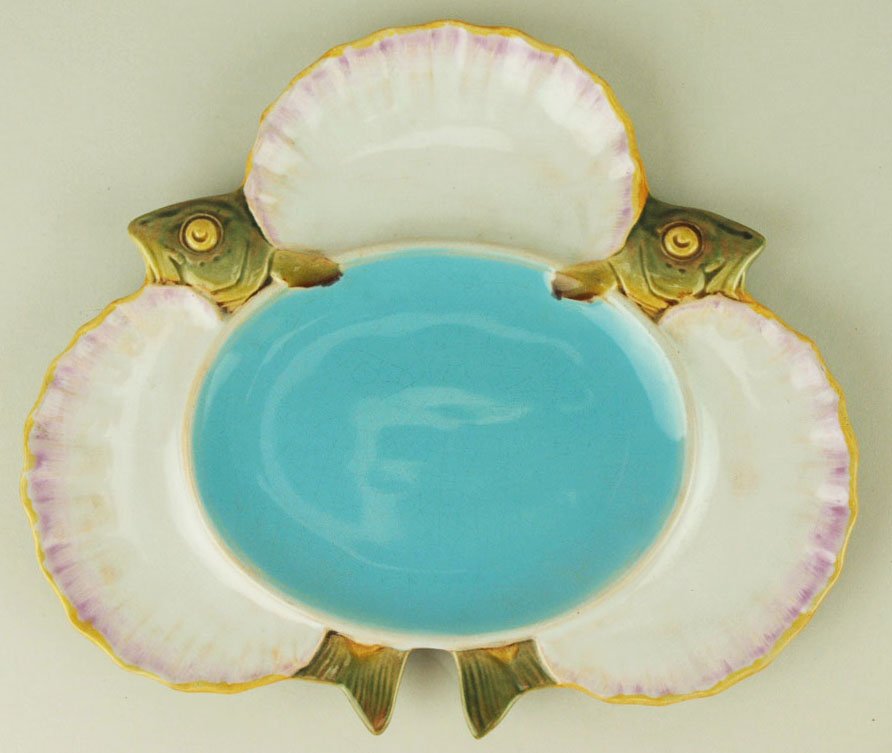 A Minton Majolica sea food serving plate c.1875.: A Minton Majolica sea food serving plate c.1875. Designed as three scallop dishes separated by two fish with a large oval turquoise centre, shape no. 1497, 9 ¾” 'CURATED & CATALOGUED BY NICOLAUS