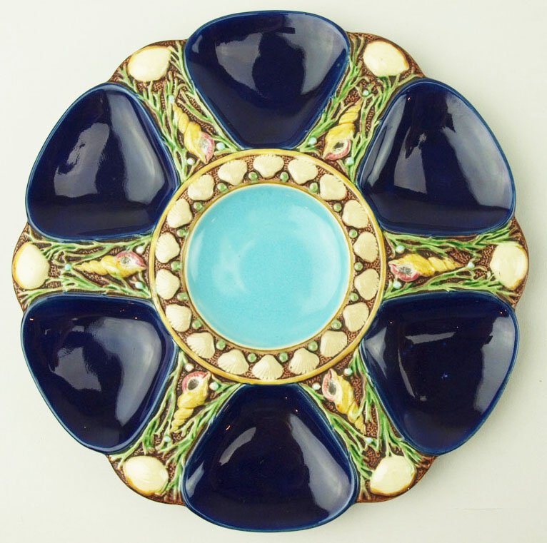 A Fine Quality Minton Majolica cobalt blue 6 well: A Fine Quality Minton Majolica cobalt blue 6 well oyster plate c.1875 Modeled as a circular plate with six cobalt blue green wells separated by shells and seaweed, the cobalt blue circular central wel