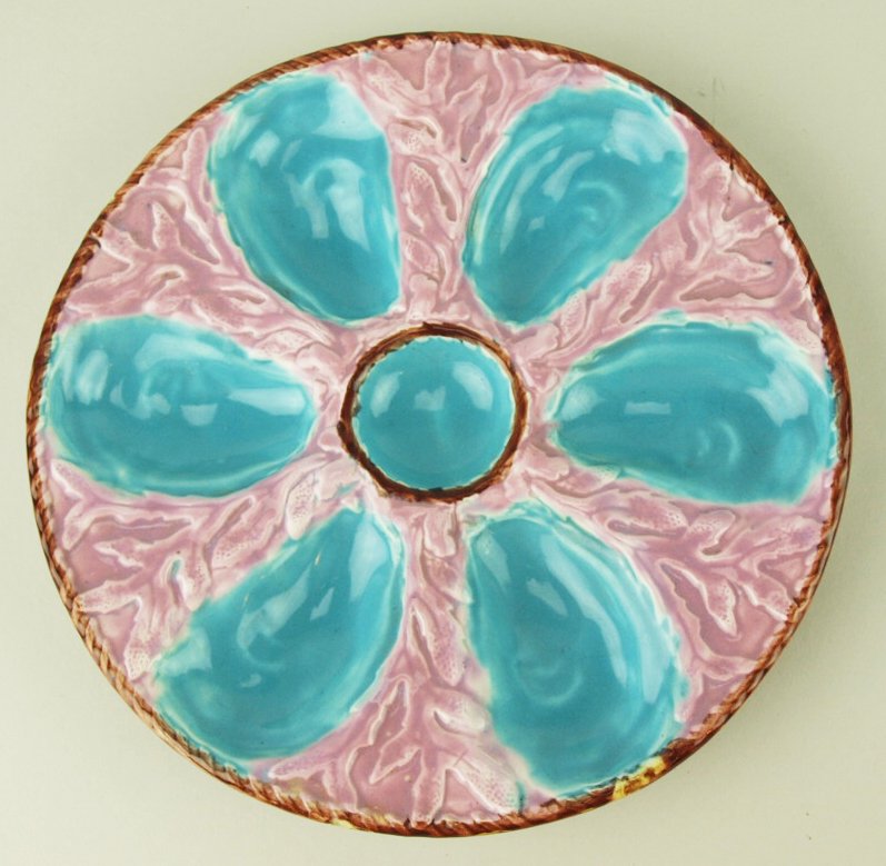A Simon Fielding shell and coral Majolica Oyster Plate: A Simon Fielding shell and coral Majolica Oyster Plate c.1875 Diam 8” The rope twist border plates modeled with 6 pink oyster shell wells & central sauce well, on a pink ground with dark pink seawee