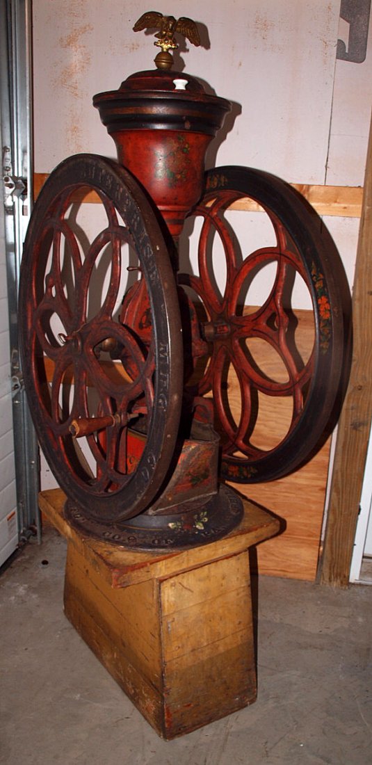 Enterprise cast iron double wheel coffee grinder No 212: Enterprise cast iron double wheel coffee grinder No 212 with eagle finial, original tin drawer and wood base, tip lid repaired, 62"h, wheels 30 1/2"d
