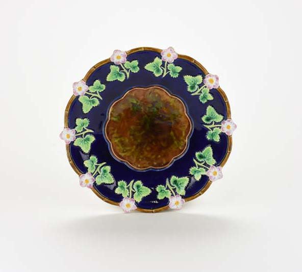 A George Jones Majolica "Strawberry Blossom" plate c.: A George Jones Majolica "Strawberry Blossom" plate c. 1875, Shape No. 3454. The shaped edge cobalt blue ground plate decorated with a continuing bank of strawberry blossoms and leaves with a mottled g