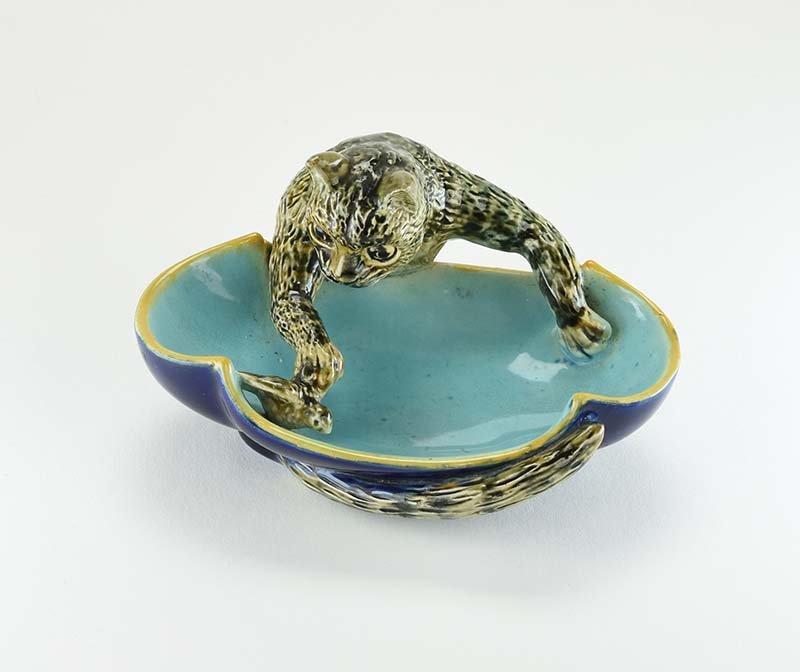 A Very Rare George Jones Majolica ‘Cat and Bird’ Ash: A Very Rare George Jones Majolica ‘Cat and Bird’ Ash Tray c.1875. Modelled as a tabby cat leaning across a turquoise colored bowl teasing a small bird, the cat’s tail appearing on the underside 