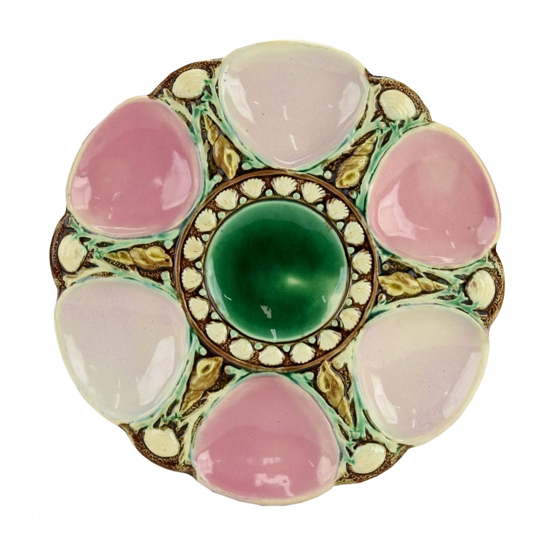 A Majolica 6 well oyster plate c.1875 Modeled as a: A Majolica 6 well oyster plate c.1875 Modeled as a circular plate with alternating white and pink wells separated by shells and seaweed, the sea green circular central well surrounded by conch shell
