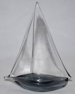 Elio Raffaeli | Murano | Sailing Boat | Oggetti | Signe: Elio Raffaeli, Sailing Boat, Signed by Artist Blown blue hue glass pulled in the shape of a sailing boat.Clear glass sail. Signed by artist on base Dimensions Height: 18.5 cm Legth: 14 cm 0% Buyers Co