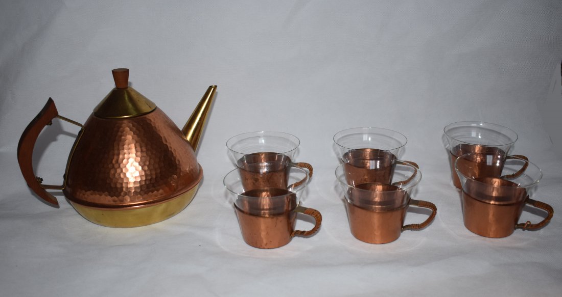 Tea Set | Teapot | 6 glasses | Manner of Auböck: Art-Deco Tea-set Copper and brass teapot with wooden handle. Set includes six copper teacups with glass inserts and wicker wrapped handles. Unclear stamp on base, possibly Kolbenheyer Dimensions: Teap