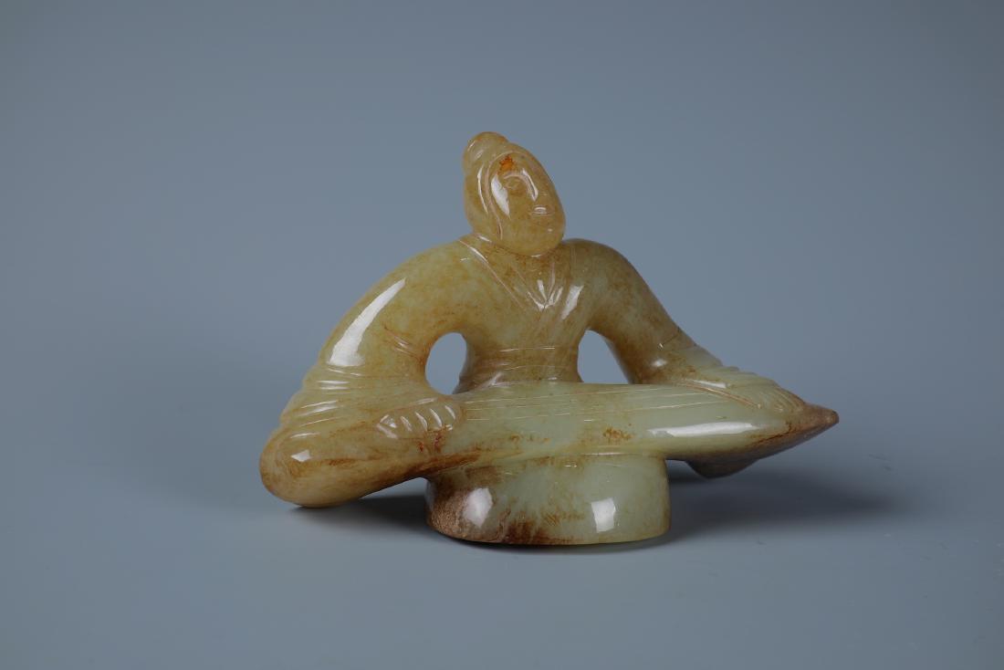 A RARE CELDON AND RUSSET JADE CARVING OF SCHOLOR: H:7CM L:11CM W:4.5CM A RARE CELDON AND RUSSET JADE CARVING OF SCHOLOR PLAYING INSTRUMENT