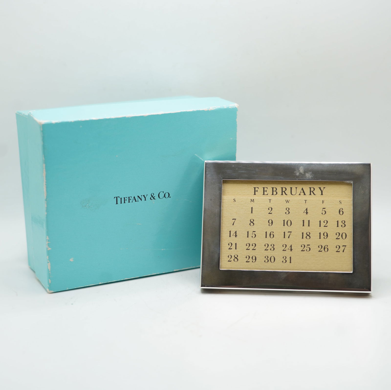 TIFFANY & CO .925 Sterling Silver Framed Calendar in Original Box with Fabric Pouch: TIFFANY & CO .925 Sterling Silver Framed Calendar in Original Box with Fabric Pouch. ize 3 3/4 in. x 2 7/8 in. ; box size 3 7/8 in. x 4 5/8 in. x 2 in.