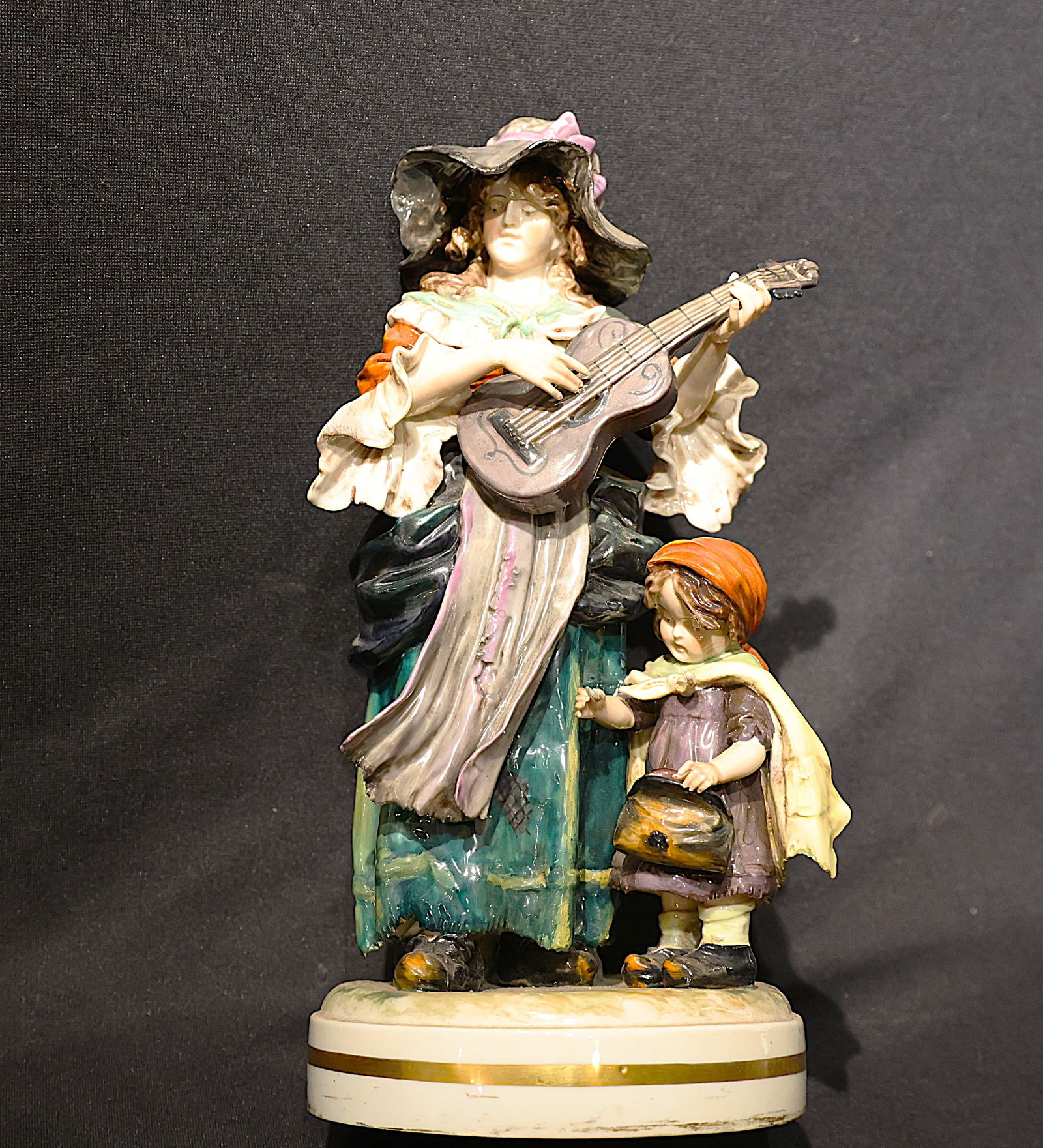 Capodimonte Fine Porcelain Figure Woman Playing Guitar Next to Young Girl 12 3/4 in. height: Capodimonte Fine Porcelain Figure Woman Playing Guitar Next to Young Girl 12 3/4 in. height, 6 1/2 inches wide, 6 inches diameter base.