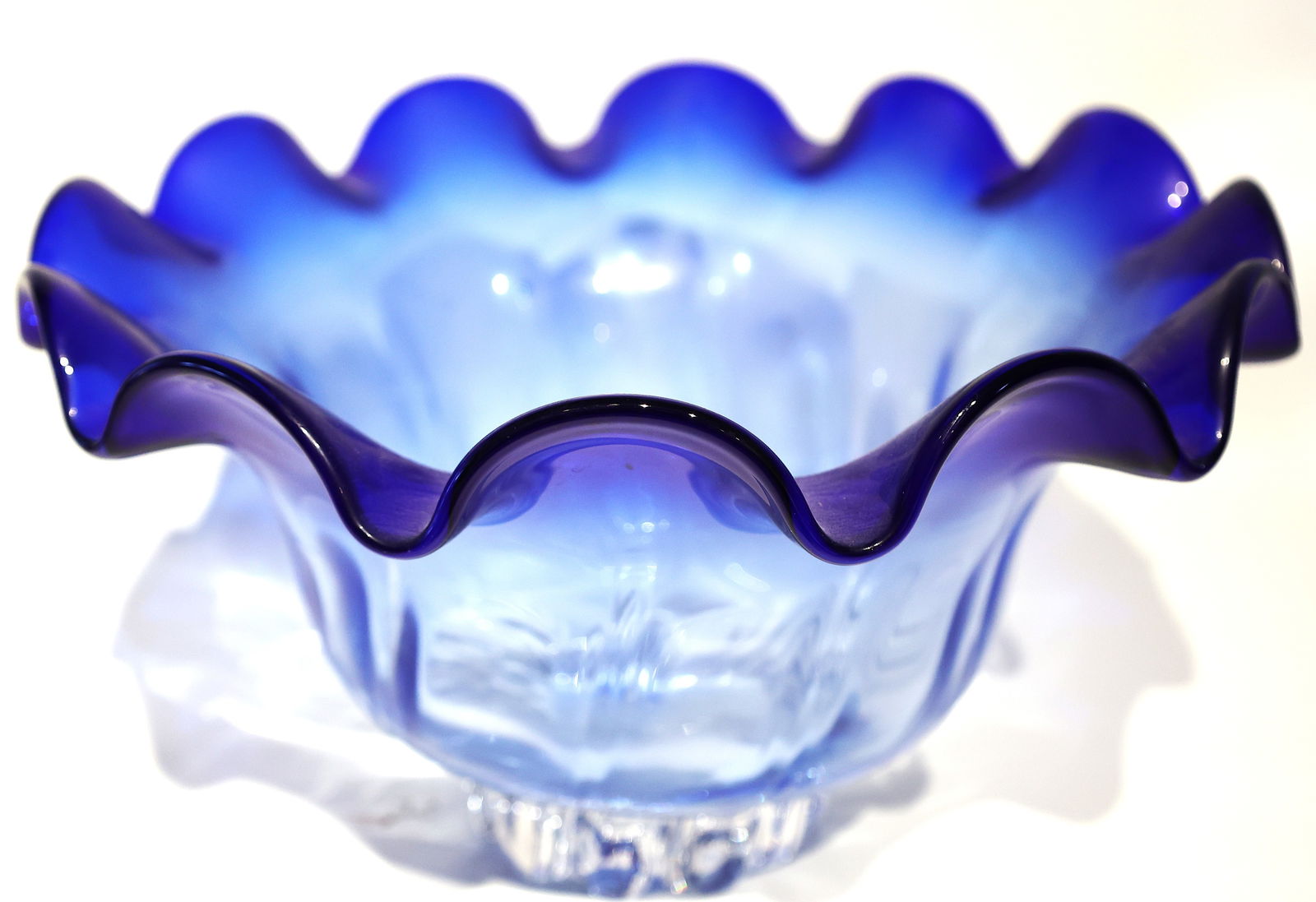 Shannon Crystal Cobalt Blue Swirled Ruffled Crystal Bowl. 12.5 inches diameter: Shannon Crystal Cobalt Blue Swirled Ruffled Crystal Bowl. Design: A hand-blown glass bowl featuring a clear base that transitions into a vibrant cobalt blue ruffled rim. Size: 7 1/2 inches height, 12