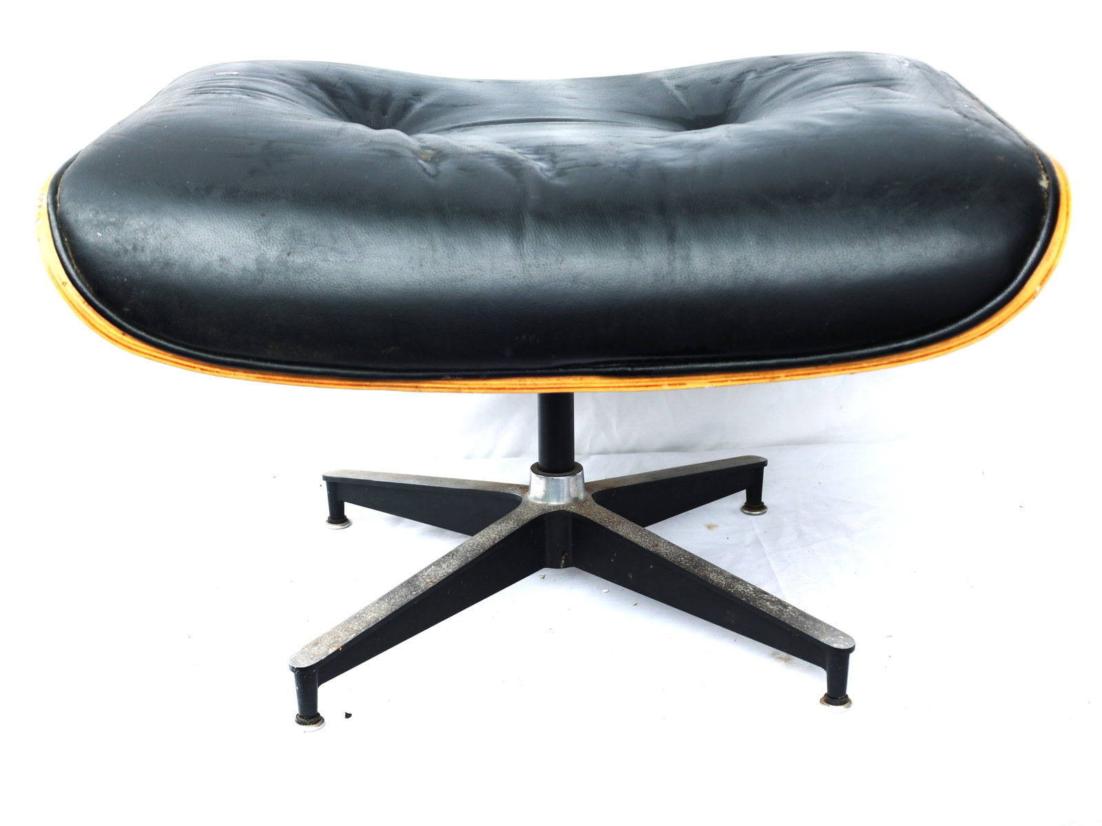 Herman Miller Eames Lounge Chair ottoman featuring a black leather cushion and molded plywood shell (1 of 4)