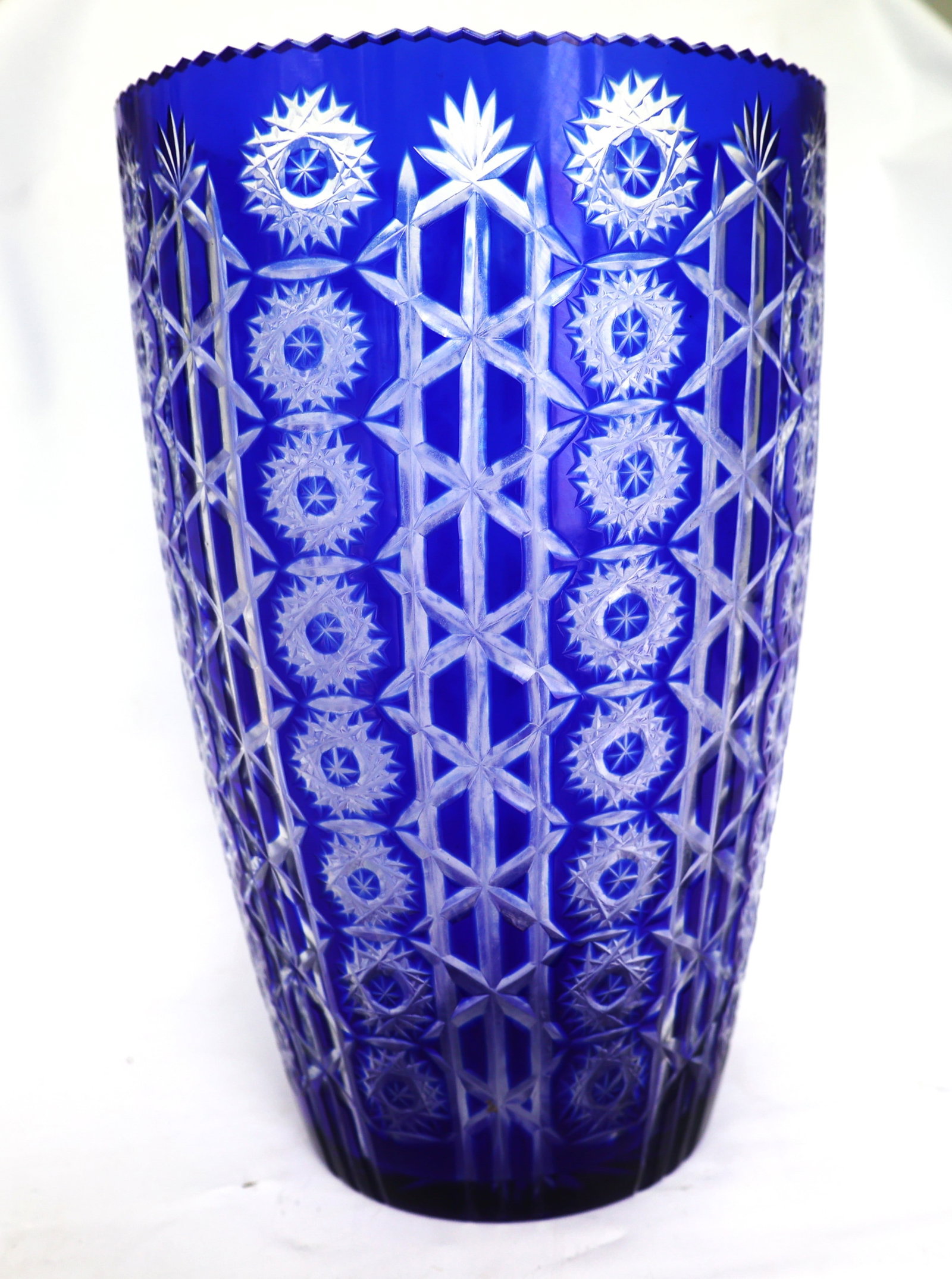 cobalt blue Bohemian vase features intricate, hand-cut diamond lattice and starburst patterns: Size: 14 inches height, 9 in. wide, 6 in. wide base ; cobalt blue Bohemian vase features intricate, hand-cut diamond lattice and starburst patterns
