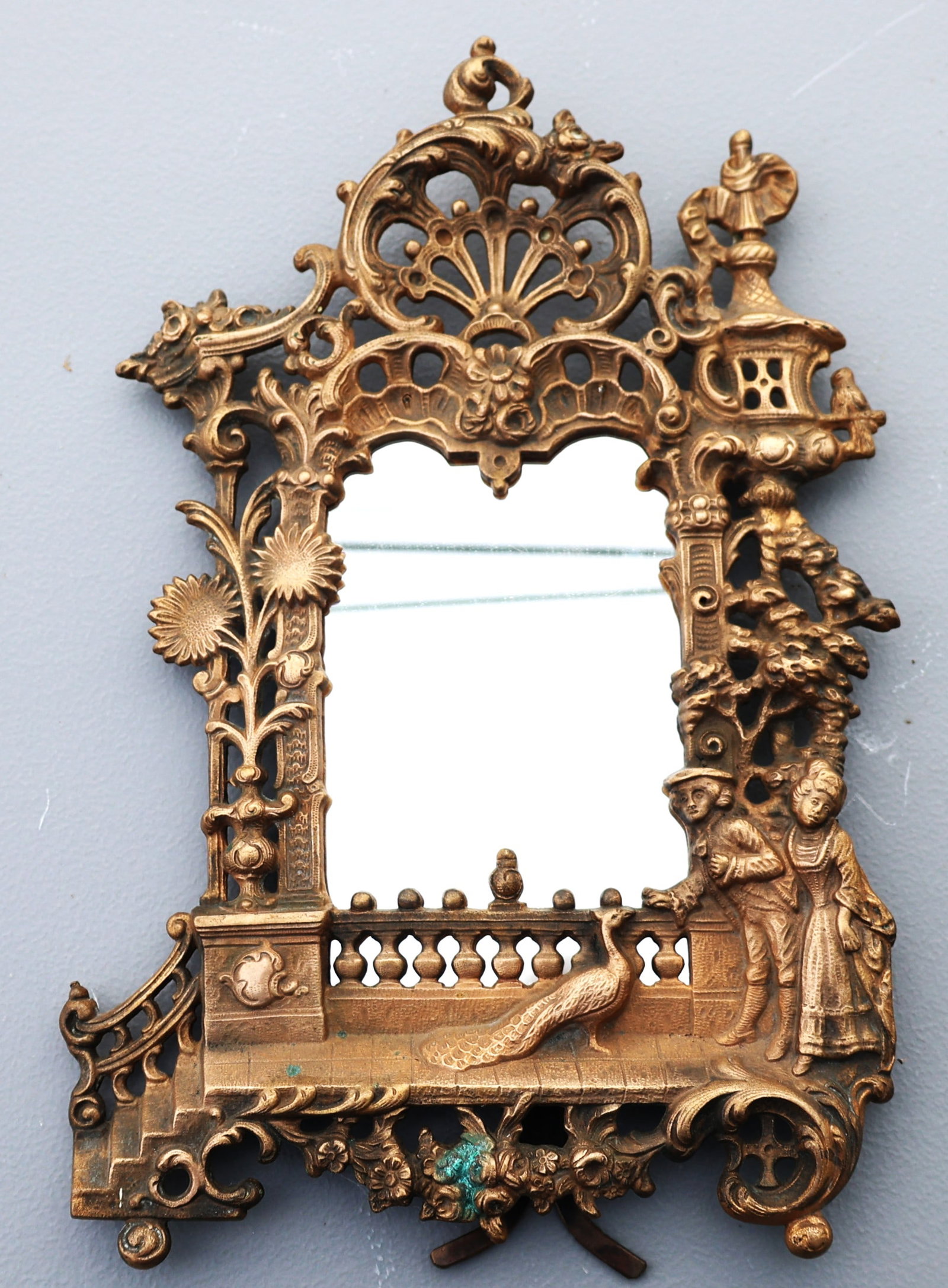 antique Victorian-style bronze wall mirror featuring ornate figures and a peacock (1 of 5)