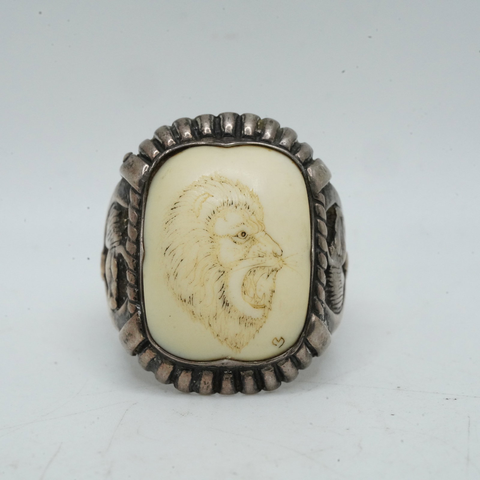 13.67 Grams Sterling Silver and Bone Etched with Lion Ring Size 12 Horses Flanking Sides: 13.67 Grams Sterling Silver and Bone Etched with Lion Ring Size 12 Horses Flanking Sides. 1 in. x 1 in.