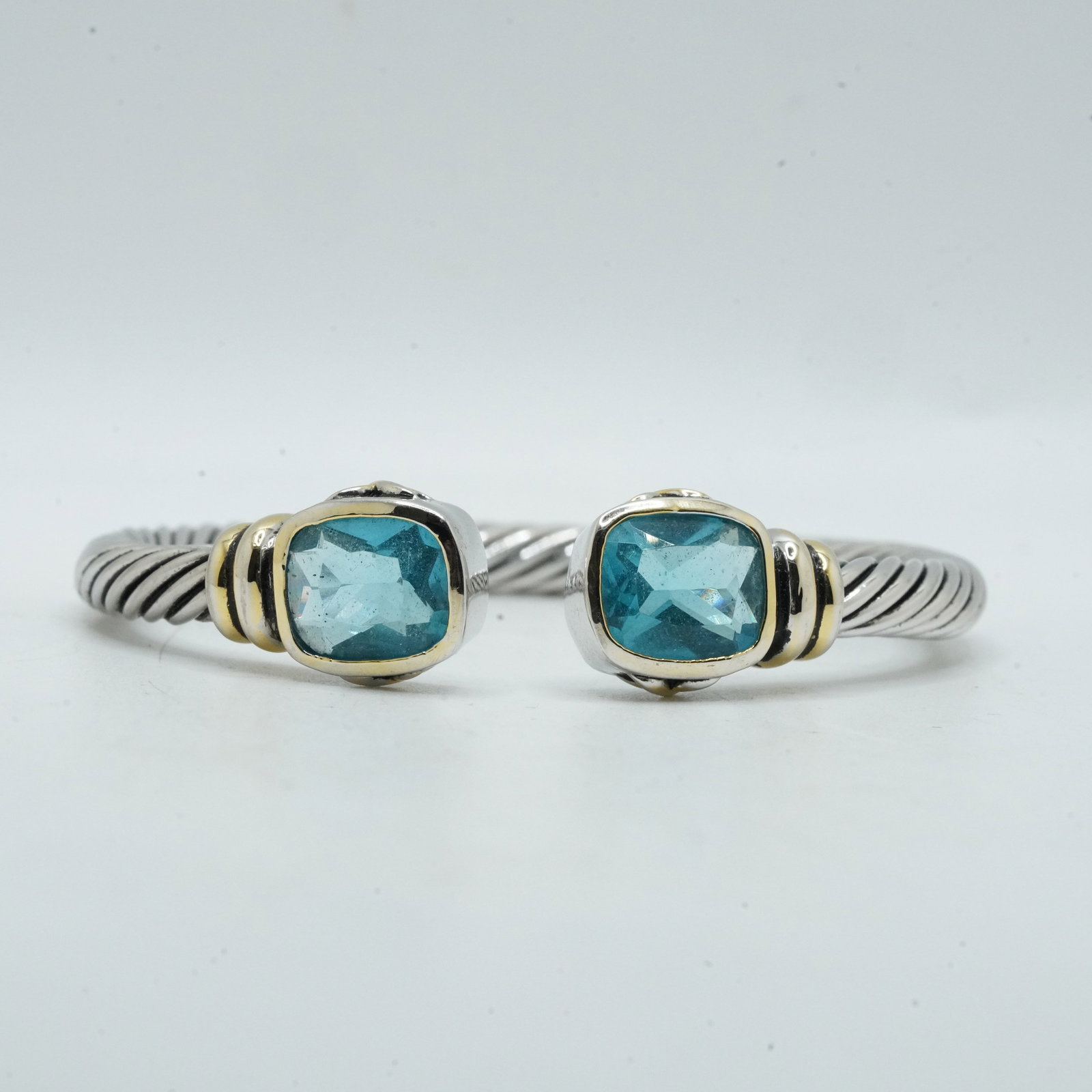 26.00 Grams .925 Sterling Silver Rope Twist Cuff Bracelet with Blue Stones and Gold Accents: 26.00 Grams .925 Sterling Silver Rope Twist Cuff Bracelet with Blue Stones and Gold Accents. 2 3/4 in. x 2 1/2 in.