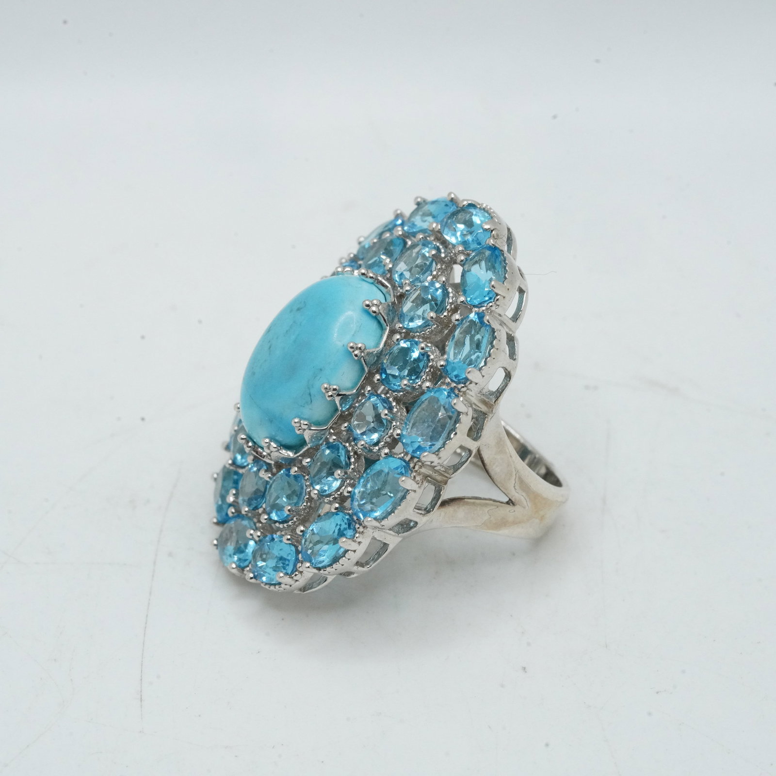 19.45 Grams .925 Sterling Silver CID Blue Topaz with Center Blue Stone Cocktail Ring Size 6.5: 19.45 Grams .925 Sterling Silver CID Blue Topaz with Center Blue Stone Cocktail Ring Size 6.5; 1 1/4 in. x 1 1/2 in.