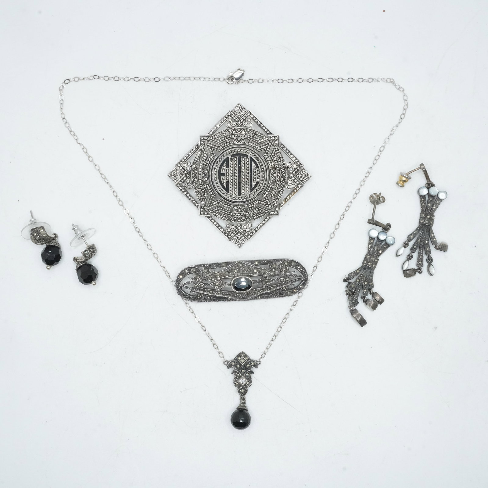 46.89 Grams .925 Sterling Silver 7 Pieces Sterling and Macasites Jewelry: Sterling Alfa Initial Pin: 46.89 Grams .925 Sterling Silver 7 Pieces Sterling and Macasites Jewelry: Sterling Alfa Initial Pin with Black Onyx 1 3/4 in dia.; Pierced Drop Earrings with MOP 2 in. x 3/4 in.; Sterling JJ Pair Drop