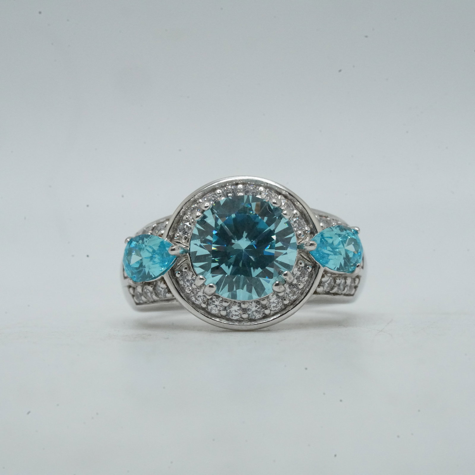 7.56 Grams .925 Sterling Silver Georgous Ring Sizw 6, Large Blue Center Stone with a Hallo: 7.56 Grams .925 Sterling Silver Georgous Ring Sizw 6, Large Blue Center Stone with a Hallo of CZ Flanked by 2 Tear Shape Blue Stones and CZ.