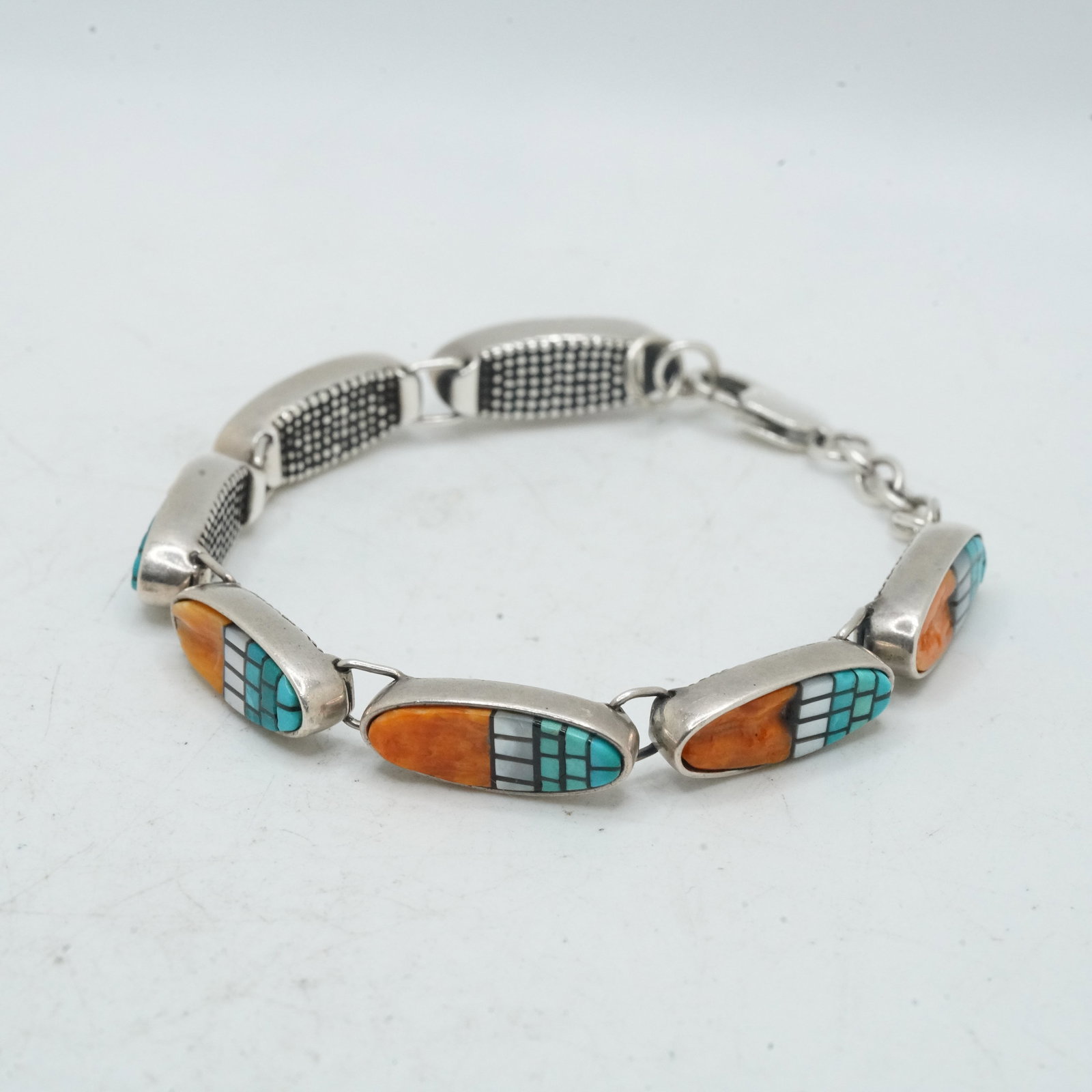 18.33 Grams .925 Sterling Silver Native American Indian Zuni Coral, Turquoise, MOP Bracelet: 18.33 Grams .925 Sterling Silver Native American Indian Zuni Coral, Turquoise, MOP Bracelet; 7 in. x 1/4 in.