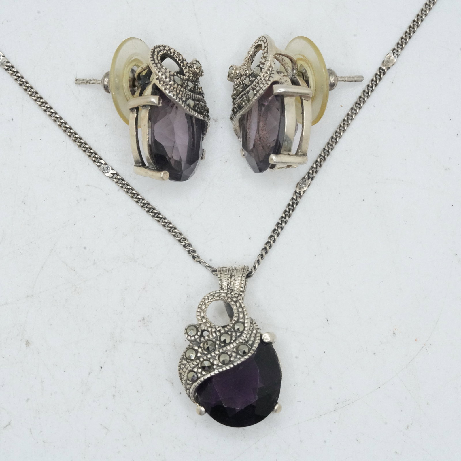 13.36 Grams .925 Sterling Silver 4-Pc. Purple Amethyst and Marcasies Set: .925 Pierced Earrings: 13.36 Grams .925 Sterling Silver 4-Pc. Purple Amethyst and Marcasies Set: .925 Pierced Earrings 1/2 in. x 3/4 in; .925 Chain 20 in length; .925 Purple Amethyst and Marcasites Pendant 1 in. x 1/2 in.