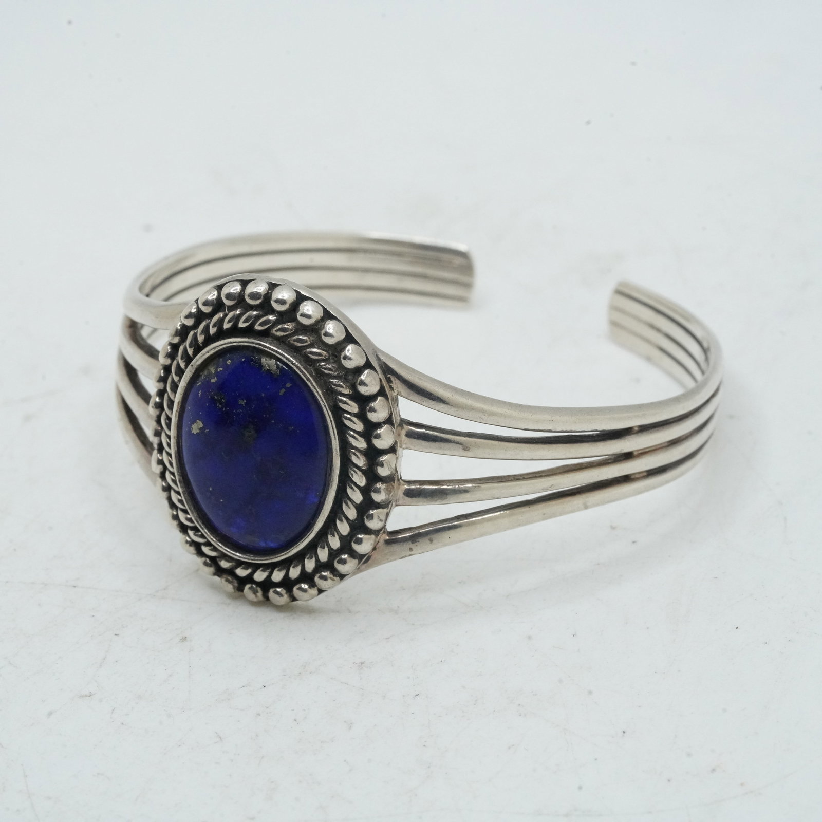 25.11 Grams .925 Sterling Silver Native American Indian Navajo Cuff Bracelet with Oval Lapis: 25.11 Grams .925 Sterling Silver Native American Indian Navajo Cuff Bracelet with Oval Lapis Center Stone, Twist and Bead Rings. 2 1/4 in. x 2 1/4 in. x 1 1/4 in.