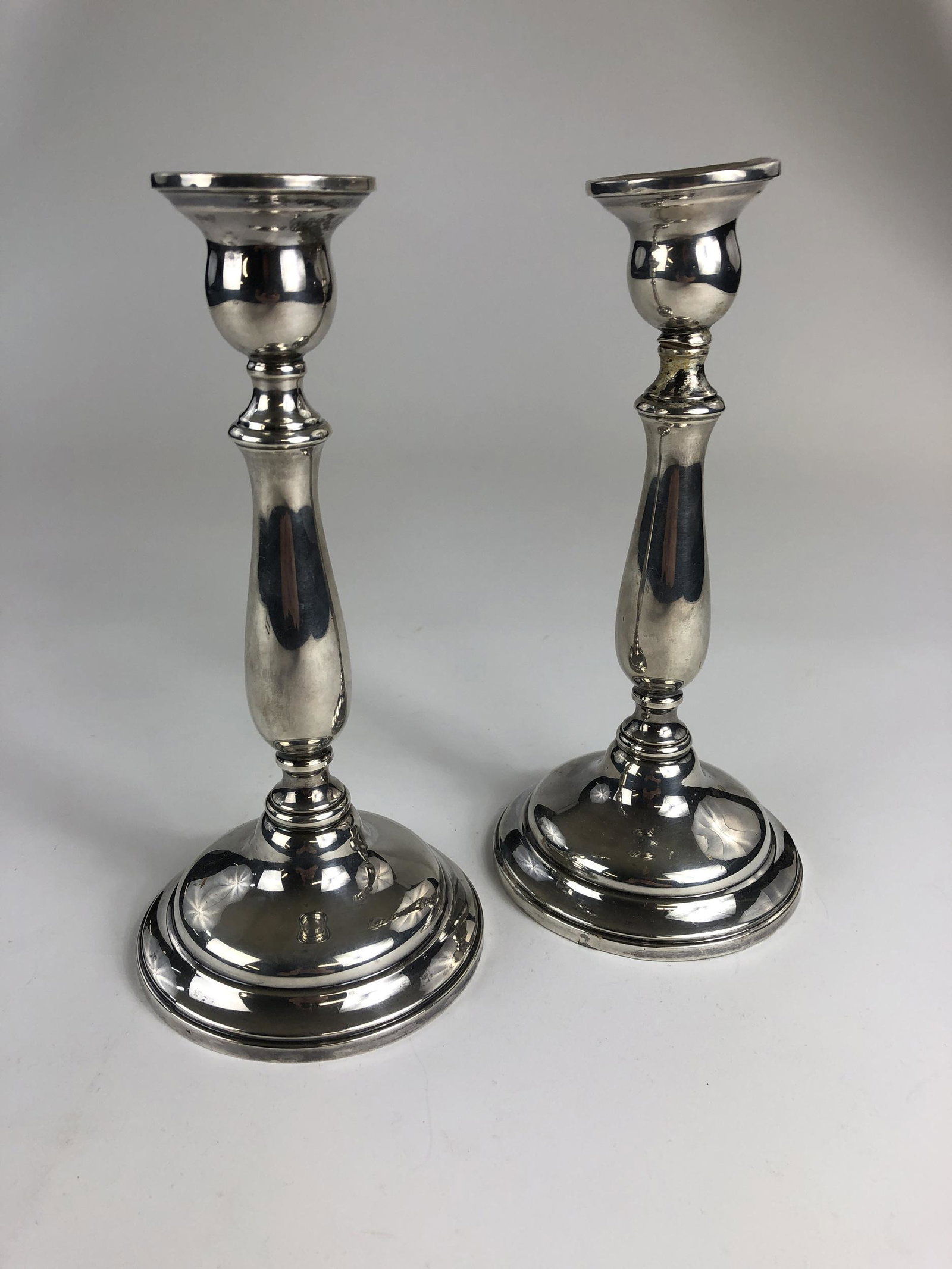 Pair of Cartier Sterling and Weighted Candlesticks: 48.02 ozt., but weighted. Each: 9.5" ht., marked to underside.