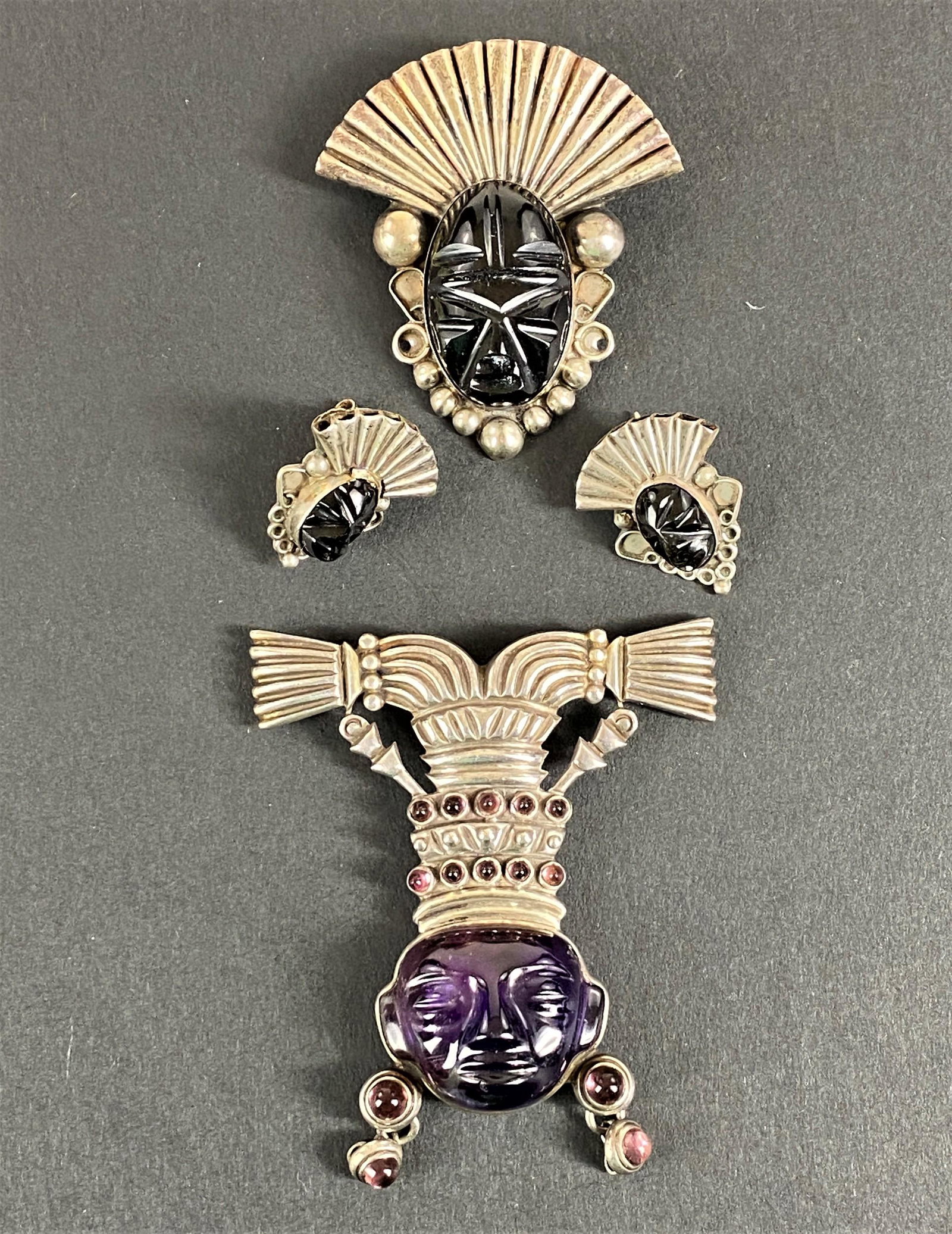 Mexican Sterling Jewelry Suite, Including Los Castillo: A pair of earrings and a brooch, each with silver mounts and stone fittings in an archaic style, along with a substantial brooch, also in archaic style, marked "Mexico, Los Castillo, Taxco, Sterling, 