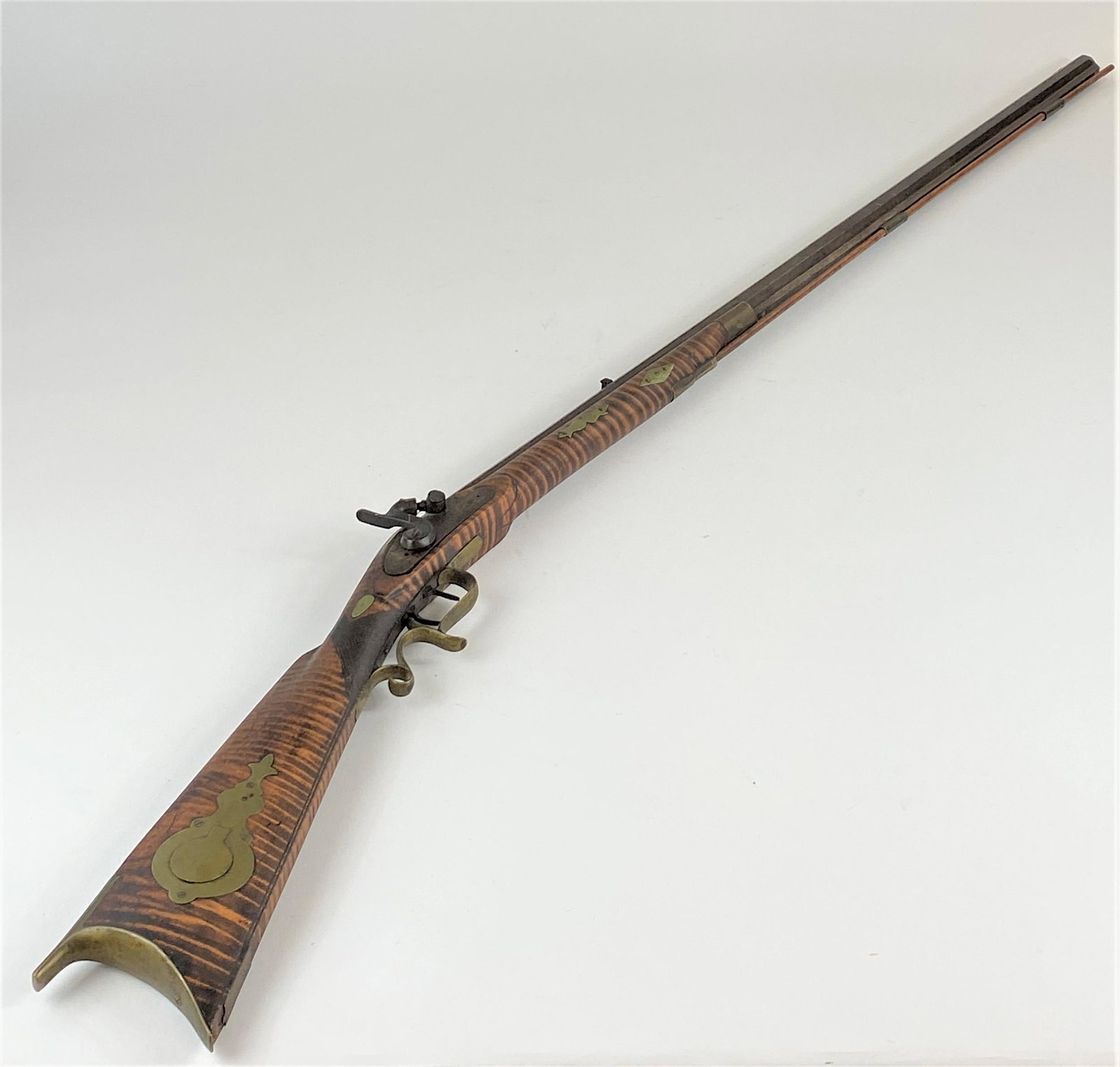 19th Century Long Rifle by L. Clark, Tiger Maple Stock: An early 19th century long rifle, marked to top of barrel L. Clark; lg. 56".