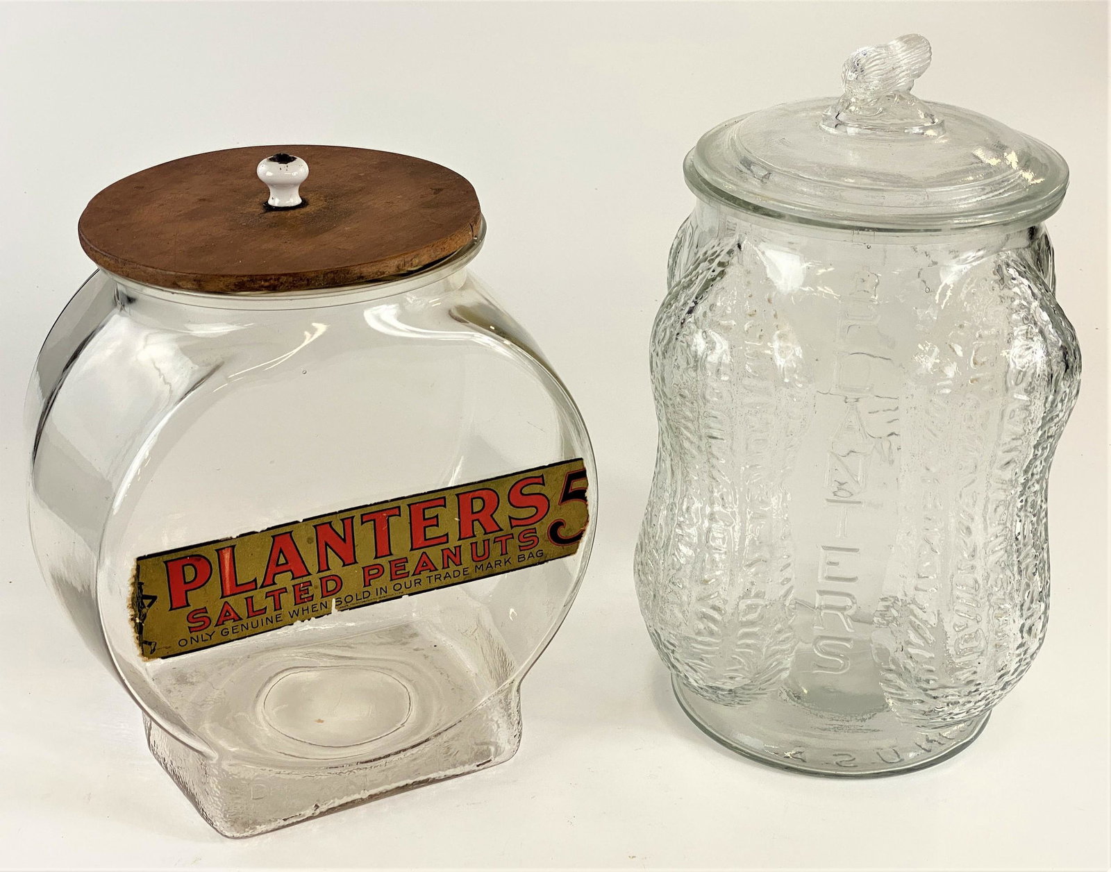 Pair of Large Vintage "Planters Peanuts" Jars: Including a large glass jar with peanuts in relief, as well as another store display jar with Planters label and top; tallest ht. 14.5"