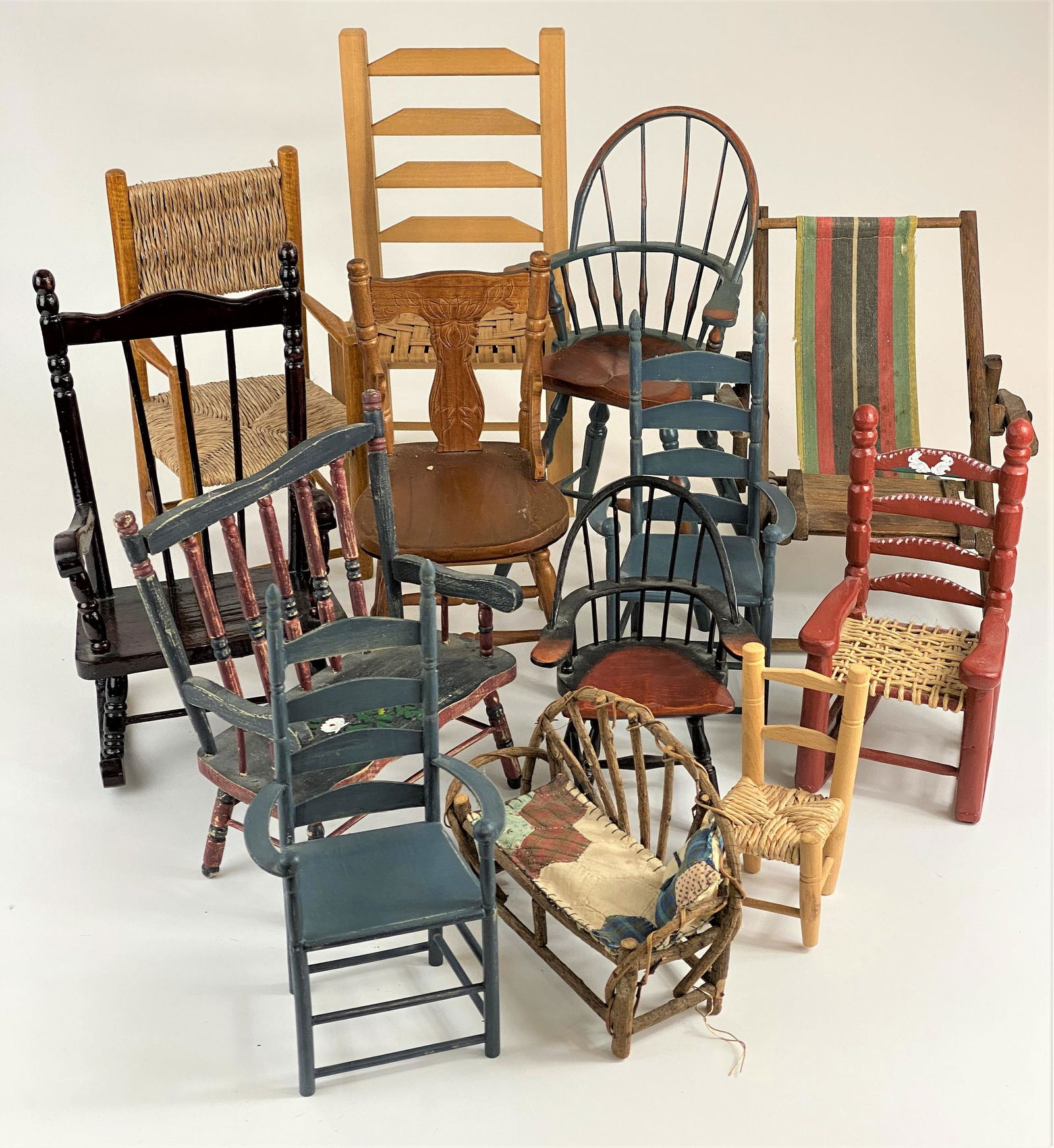 Collection of Miniature Chairs: Grouping of 13 miniature chairs of various ages, including grass-seated chair, lawn lounger, ladder back, primitive bent wood, rocker and others; tallest 16"