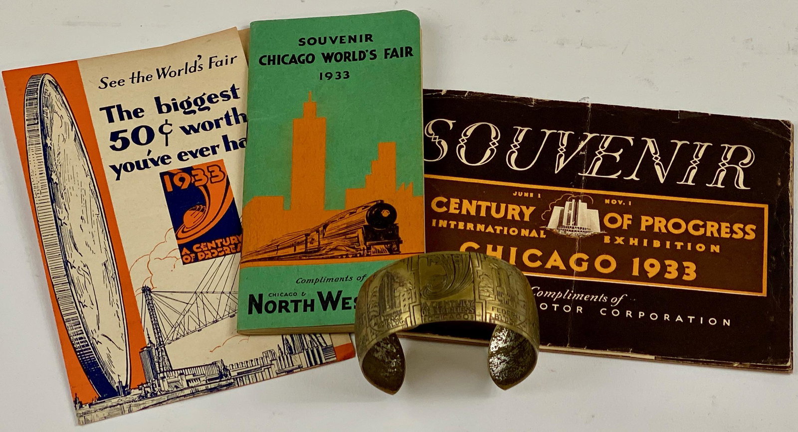 1933 Chicago World's Fair Ephemera and Bracelet: 4 items, including three pamphlets, and a brass incised bracelet depicting buildings at the fair and quotations; bracelet 2.25" diameter.