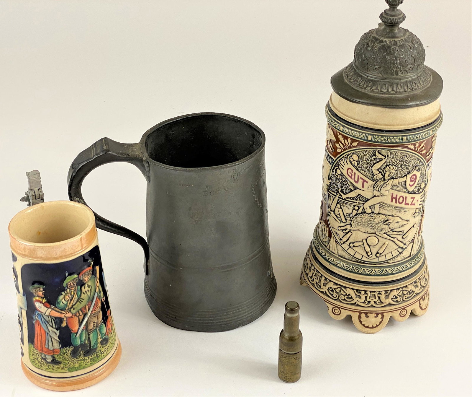 Grouping of Beer Vessels and Opener: Two German steins with the largest being a half liter, a pewter quart stein with inscription, and interesting Anheuser Busch hideaway corkscrew; tallest 8" H.