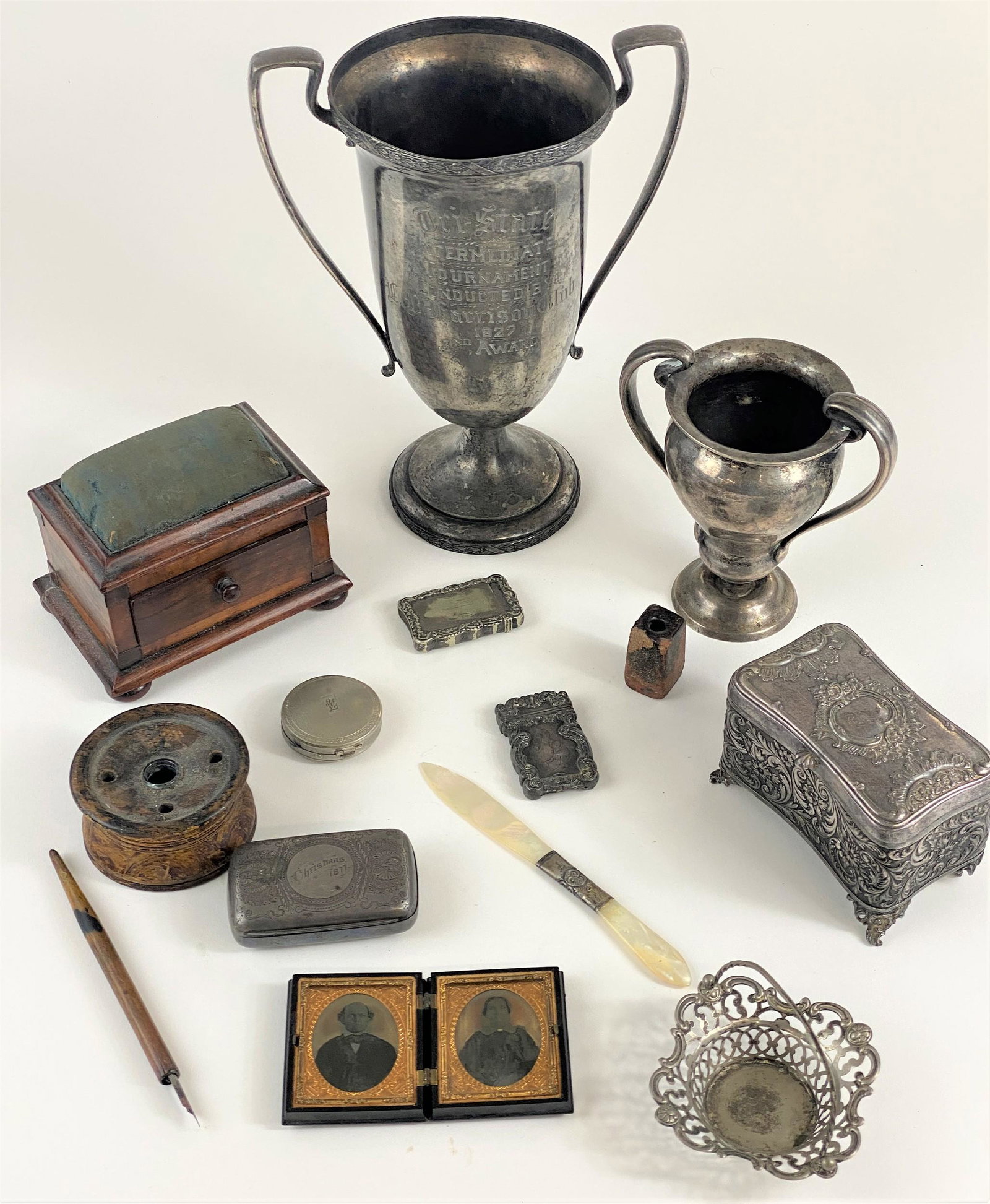 Group of Desk Accessories, Match Safe and Trophies: A large lot of desk accessories and other novelty objects, including a pair of inkwells, a mother of pearl letter opener, a golfer match safe in sterling, a small trophy in sterling, a large plated tr