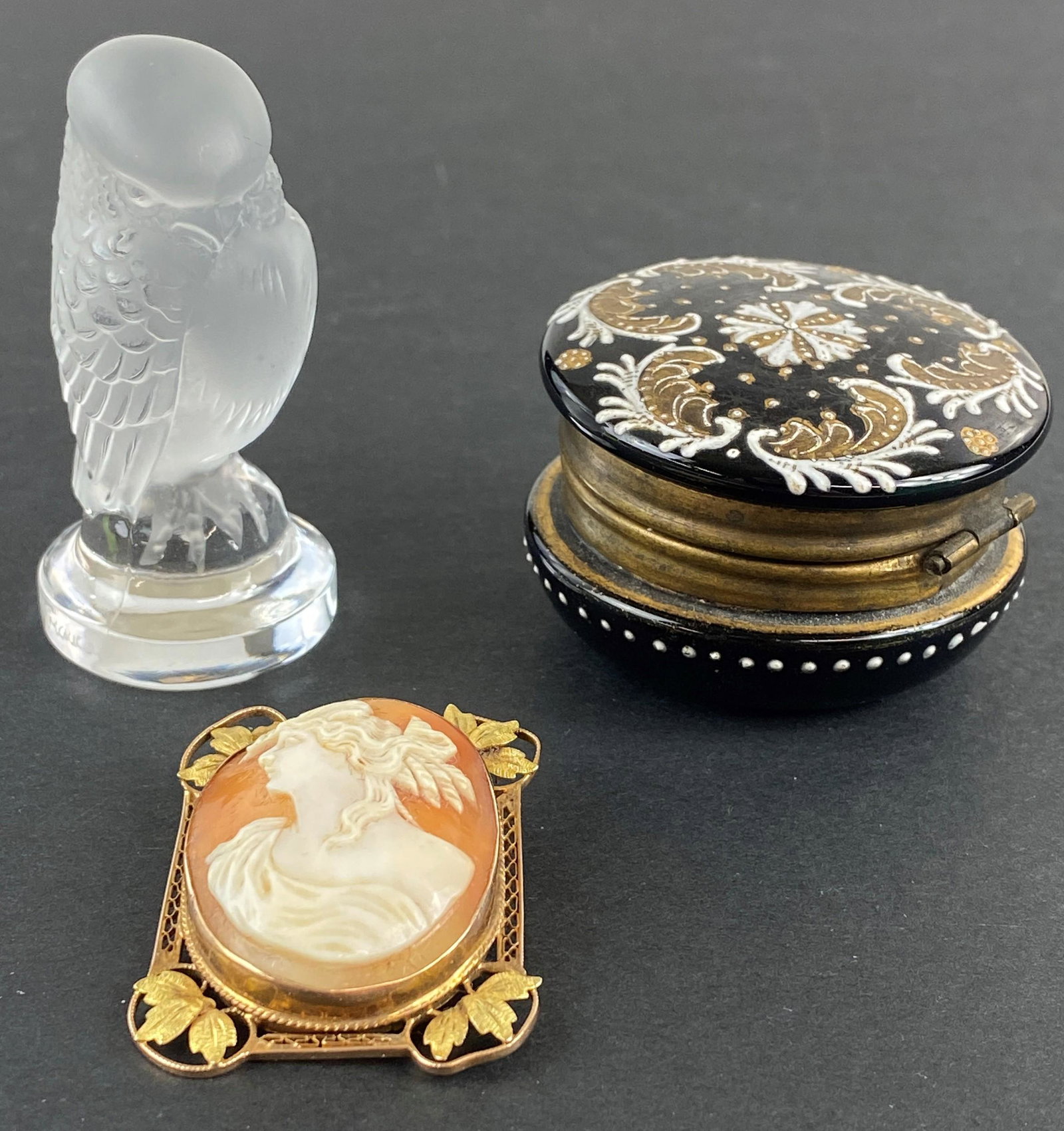 French Cameo, Lalique Owl, and Enamel Pill Box: A group of three French objects, including a Lalique owl, signed, and cameo with filigree mount, and glass pill box with enamel decoration; ht. of tallest 2.5".