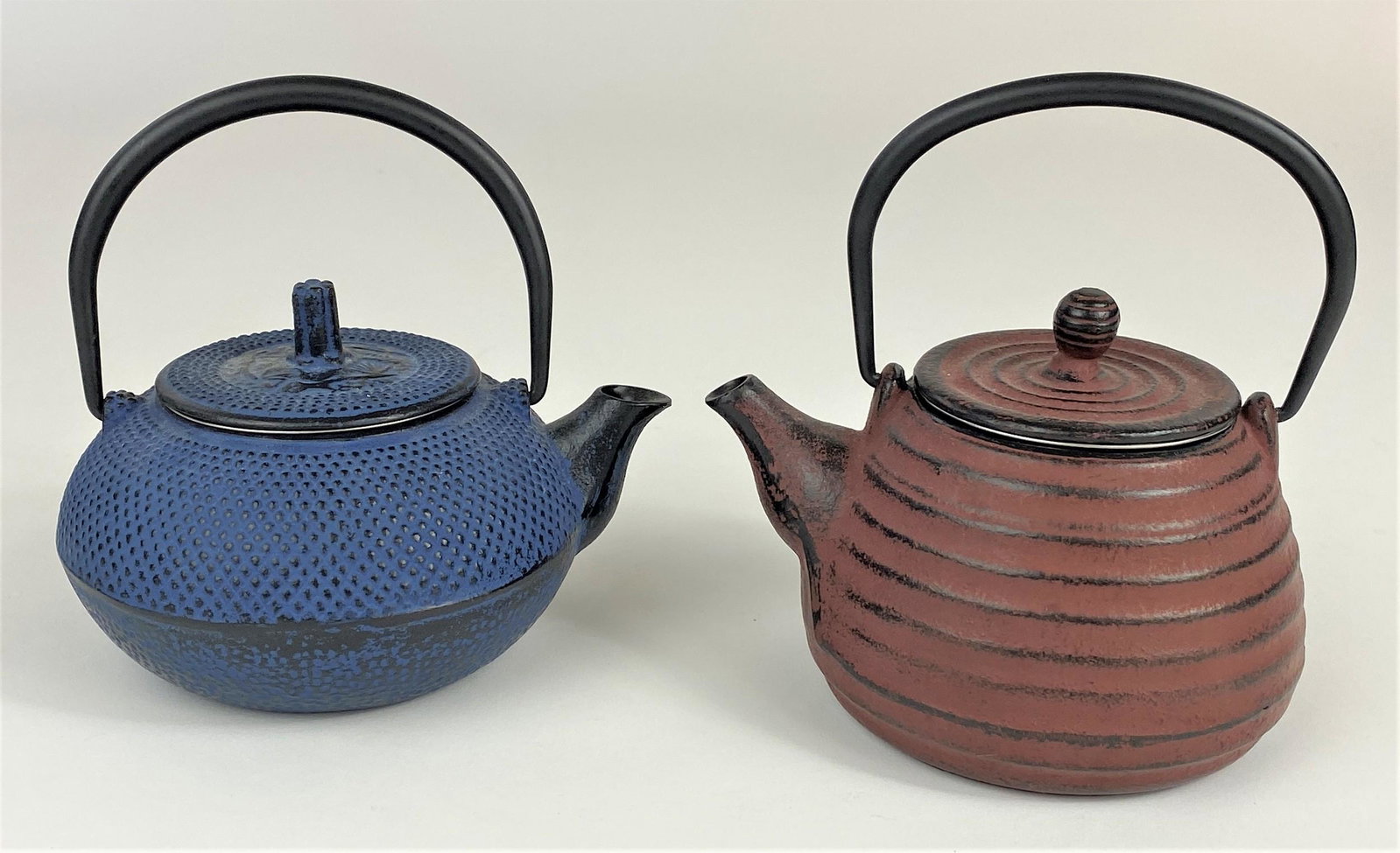 Pair of Asian Cast Iron and Painted Teapots and: A pair of cast iron teapots, each signed, with strainers built into interior; ht. of each 6" (including handles).