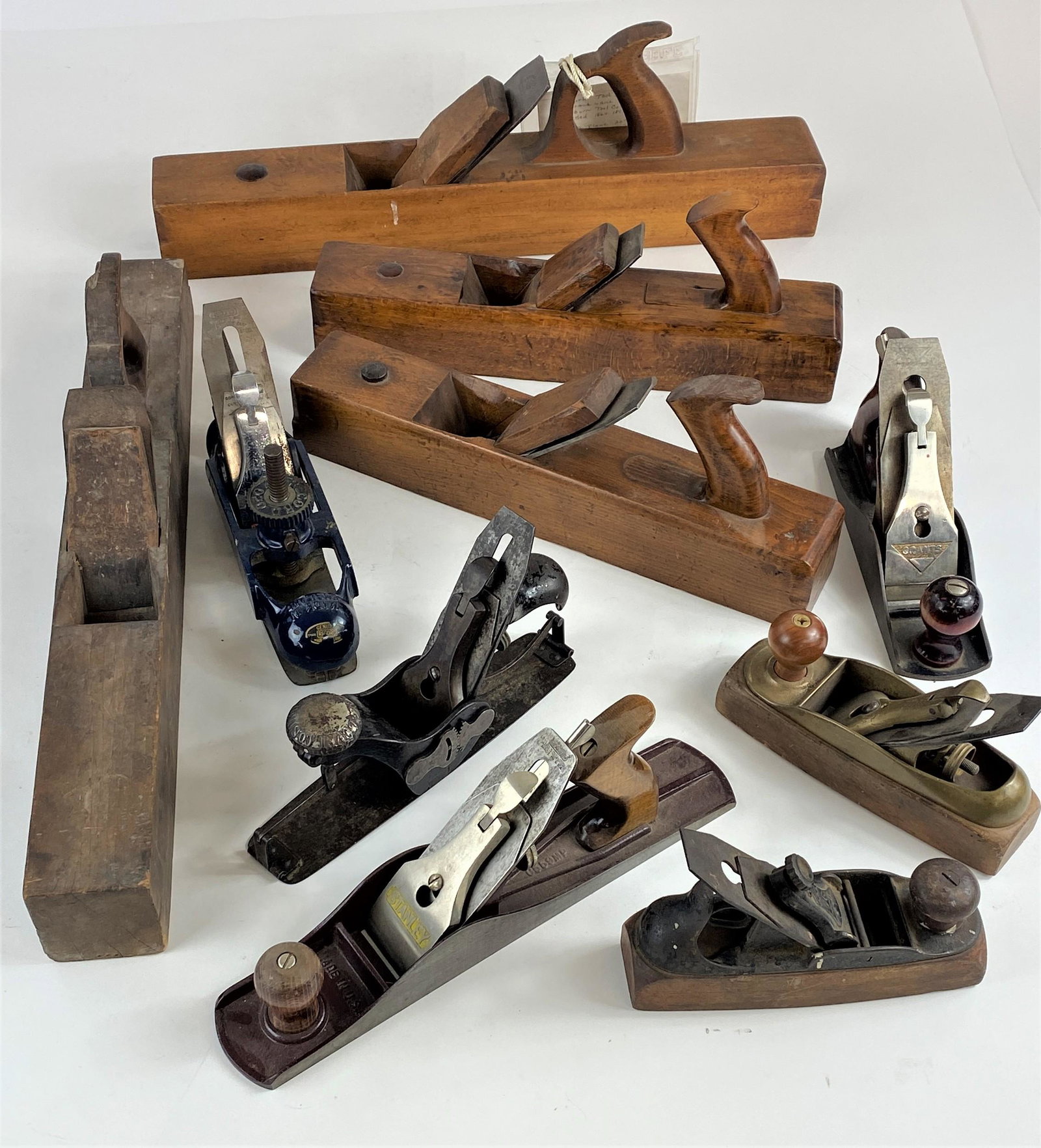 Large Collection of 19th and 20th Century Wood Planes: A collection of 10 wood planes in varying sizes, including a pair of large planes, 19th century, one identified as New York manufacturer Auburn Tool Co., several Stanley planes, one English in blue pa