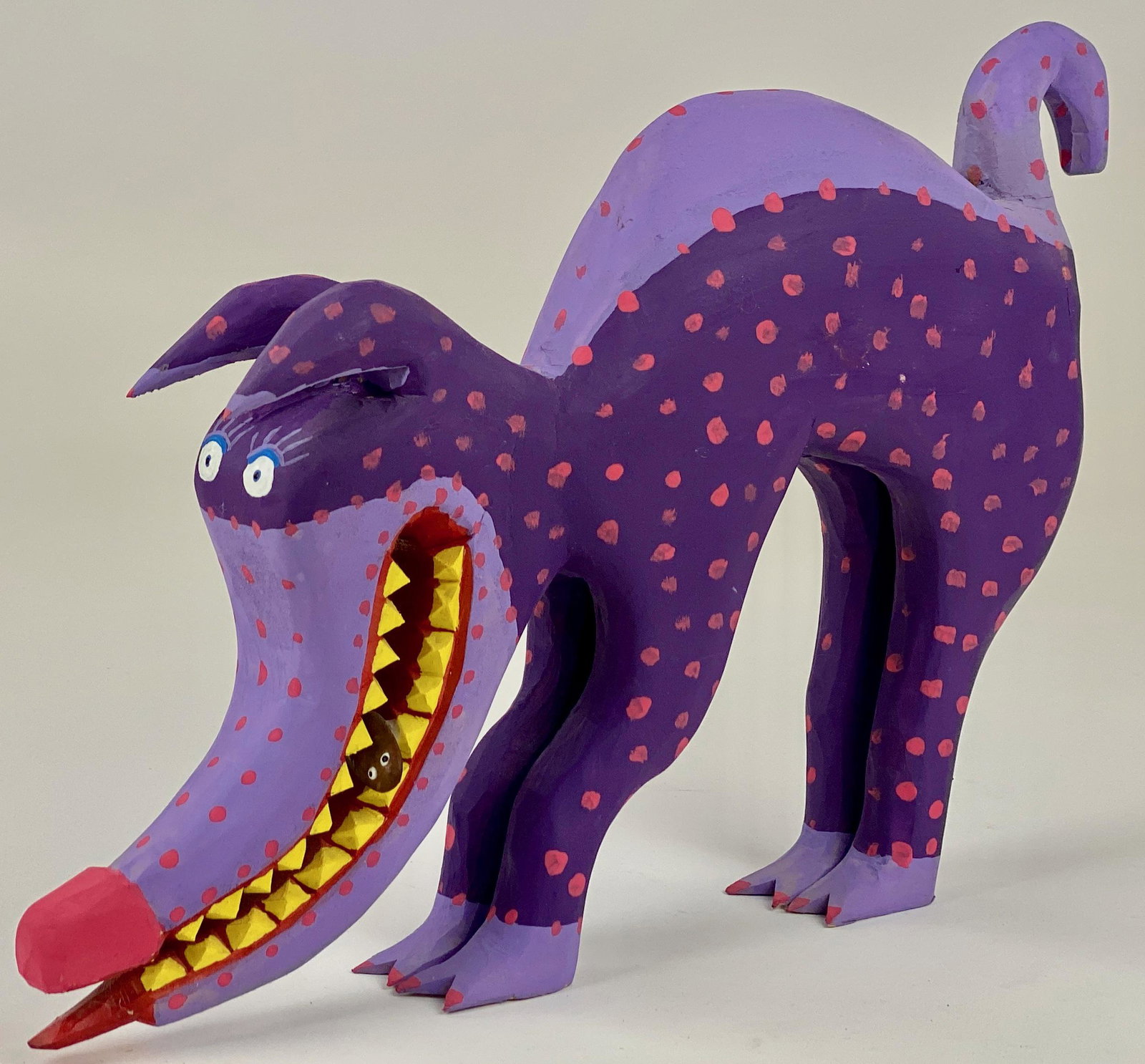 Minnie Adkins (Kentucky), "Roach Terminator": A nicely carved colorful folk art dog, signed and dated 2006 to underside. Dog is posed in a stretch position and has a small brown fish in mouth with tongue sticking out; 9" ht. x 11.5" wd. From the 