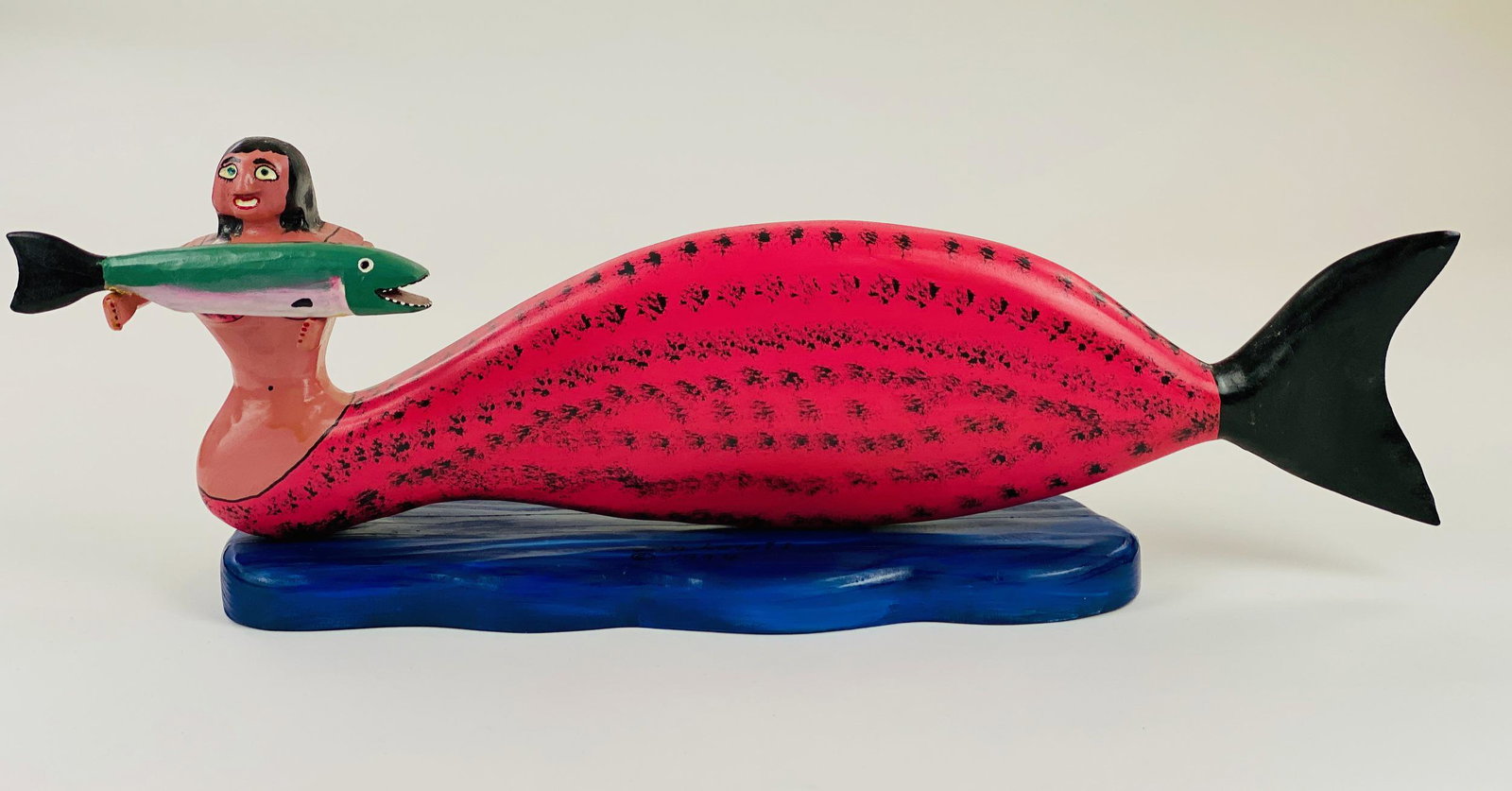 Jim Lewis (Kentucky, b. 1948), Carved Mermaid: A brilliantly carved pink and black spotted mermaid holding a fish by Kentucky folk art carver, Jim Lewis: 7.5" ht. x 20" wd. From the collection of Dr. Gerald and Barbara Theisen, Georgetown, KY.