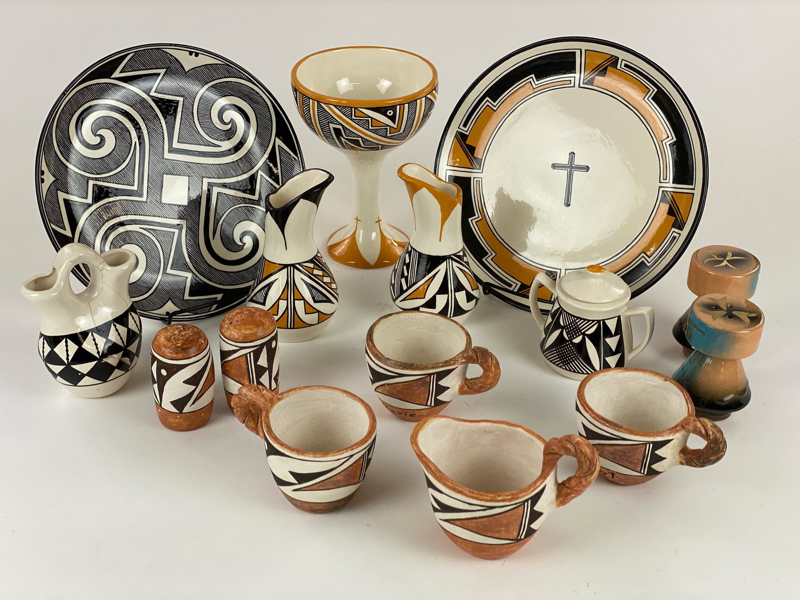 Collection of Southwestern Polychrome Tablewares: Mostly Acoma, including 16 pieces of decorated tablewares, with plates, cups (named for a family and signed to underside), shakers, chalice and miniature pitchers, including several works by Lois John